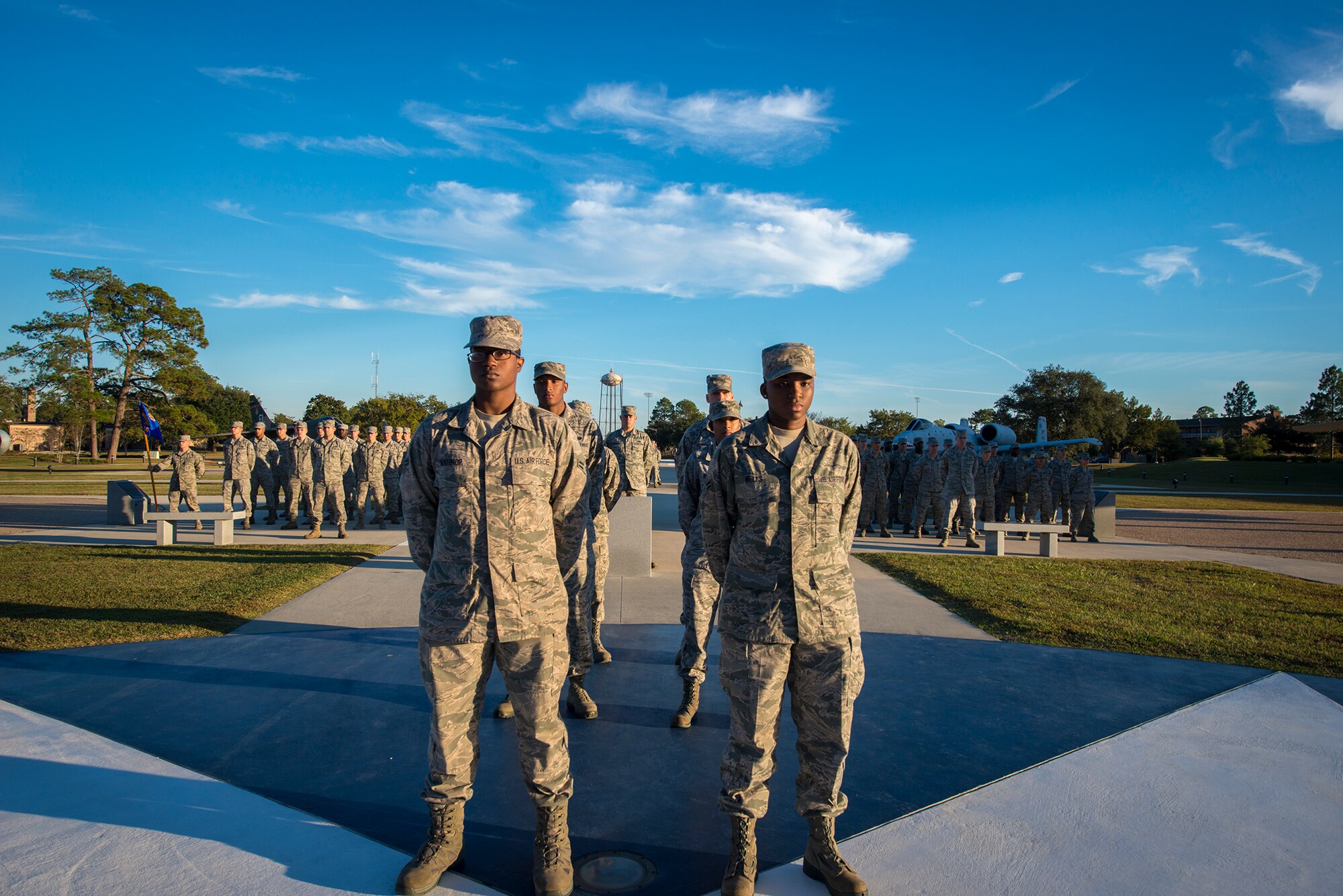 U.S. Air Force Airman 1st Class Shannon Winthrop, left, 23d Communications Squadron network administrator, and Airman 1st Class Taylor Wells, 23d CS client systems technician, stand at the front of a flag detail and two flights of Airmen at Moody Air Force Base, Ga., Nov. 8, 2013. The detail ceremoniously lowered and folded the flag to honor veterans. (U.S. Air Force photo by Airman 1st Class Ryan Callaghan/Released)
