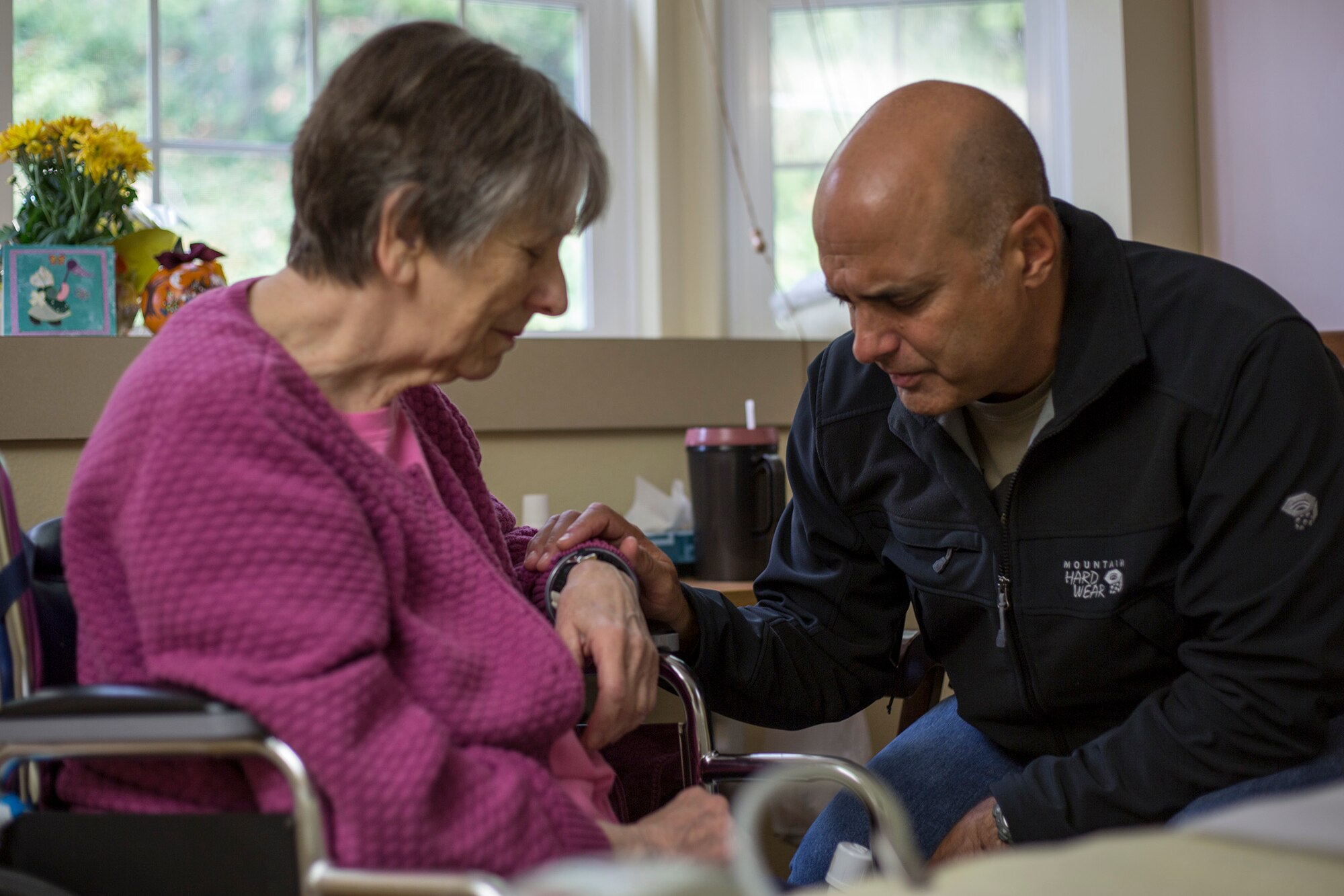 Chaplain (Maj.) Pierre Allegre, the 446th Airlift Wing chaplain, shares a prayer with a member of his civilian congregation who suffered an injury in her home, Oct. 30. Allegre is a pastor for a church in Lacey, Wash., and he said he's blessed to lead a congregation, which supports him in his capacity as an Air Force Reserve chaplain. (U.S. Air Force Reserve photo by Master Sgt. Jake Chappelle)