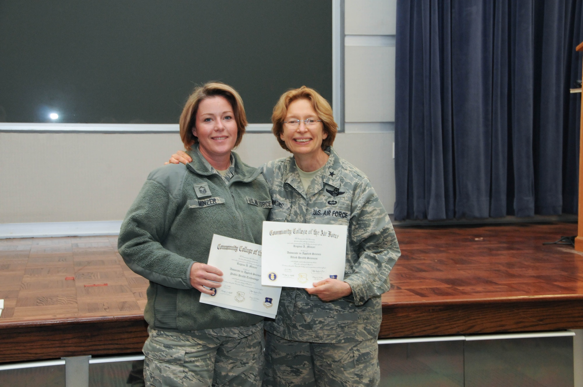 U.S. Air Force Master Sgt. Regina Minzer, left, a member of the 166th Medical Group, 166th Airlift Wing, receives a certificate from Brig. Gen. Carol Timmons, assistant adjutant general for air, Delaware National Guard to recognize Minzer’s attainment of a Community College of the Air Force associate of applied science degree in public health technology and a second AAS in allied health sciences at a CCAF Class of October 2013 graduation ceremony held Nov. 3, 2013 at the New Castle Air National Guard Base, Del. (U.S. Air National Guard photo by Tech. Sgt. Robin Meredith)