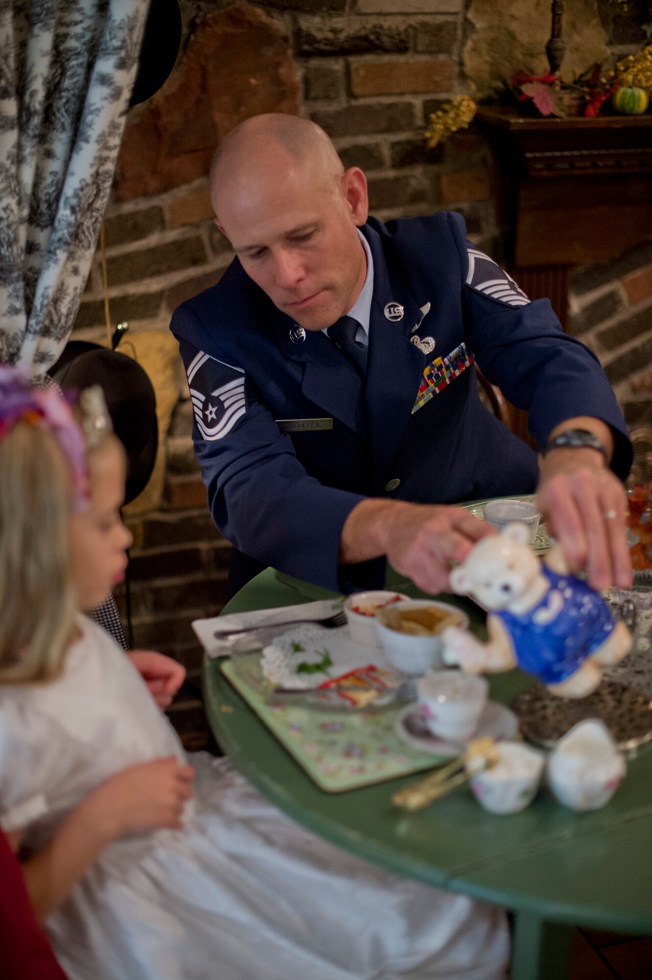 Senior Master Sgt. Greg Wolhfeil pours tea for his daughter at the Avalon Tearoom & Pastry Shoppe in White Bear Lake, Minn. on Nov. 8.  After returning from a long training course away from home, Wolhfeil planned special ‘dates’ with each one of his family members to solidify family bonds.  “When I asked my 7-year old daughter where she wanted to go, it was her idea to go to tea,” said Wolhfeil.  (U.S. Air National Guard photo by Tech. Sgt. Lynette Olivares/Released)