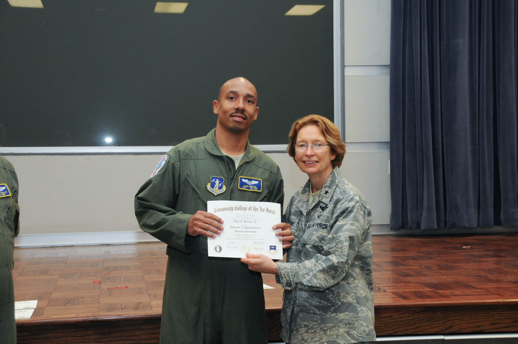 U.S. Air Force Tech. Sgt. Alvin Henson, left, a member of the 142nd Airlift Squadron, 166th Airlift Wing, receives a certificate from Brig. Gen. Carol Timmons, assistant adjutant general for air, Delaware National Guard to recognize Henson’s attainment of a Community College of the Air Force associate of applied science degree in aviation operations at a CCAF Class of October 2013 graduation ceremony held Nov. 3, 2013 at the New Castle Air National Guard Base, Del. (U.S. Air National Guard photo by Tech. Sgt. Robin Meredith)
