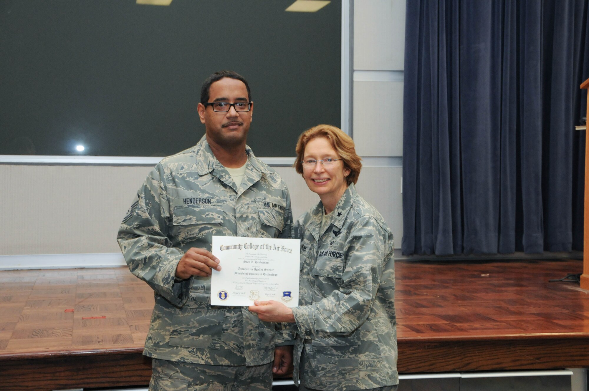U.S. Air Force Master Sgt. Sean Henderson, left, a member of the 166th Medical Group, 166th Airlift Wing, receives a certificate from Brig. Gen. Carol Timmons, assistant adjutant general for air, Delaware National Guard to recognize Henderson’s attainment of a Community College of the Air Force associate of applied science degree in biomedical equipment technology at a CCAF Class of October 2013 graduation ceremony held Nov. 3, 2013 at the New Castle Air National Guard Base, Del. (U.S. Air National Guard photo by Tech. Sgt. Robin Meredith)