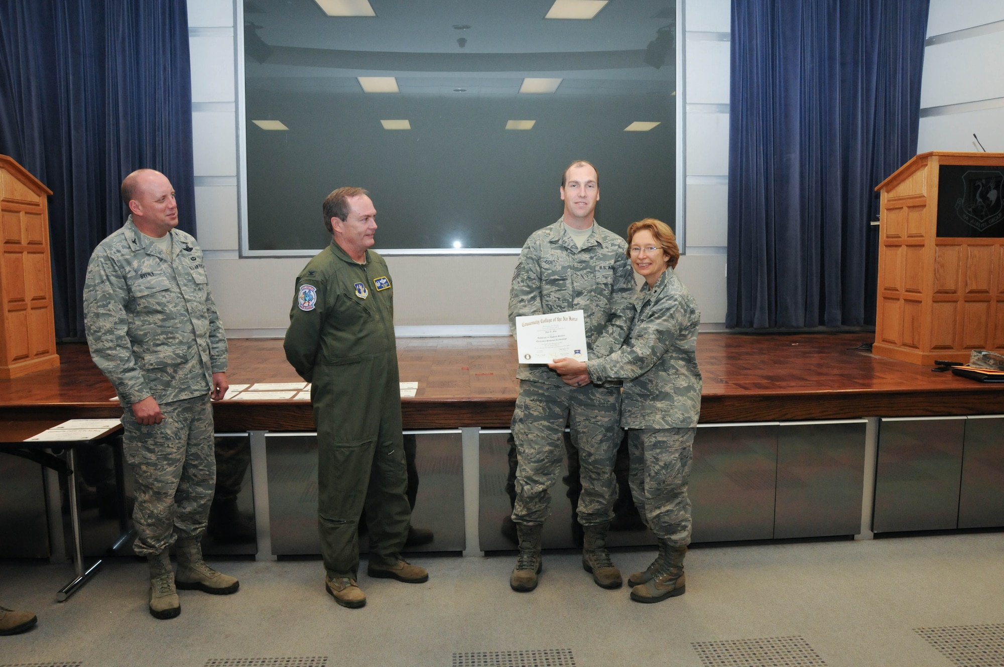 U.S. Air Force Tech. Sgt. Jon Goe, second from right, a member of the 166th Network Warfare Squadron, 166th Airlift Wing, receives a certificate from Brig. Gen. Carol Timmons, assistant adjutant general for air, Delaware National Guard to recognize Goe’s attainment of a Community College of the Air Force associate of applied science degree in electronic systems technology at a CCAF Class of October 2013 graduation ceremony held Nov. 3, 2013 at the New Castle Air National Guard Base, Del. 166th AW Commander Col. Mike Feeley, second from left, is next to 166th AW Vice-Commander Col. Dave Byerly. (U.S. Air National Guard photo by Tech. Sgt. Robin Meredith)