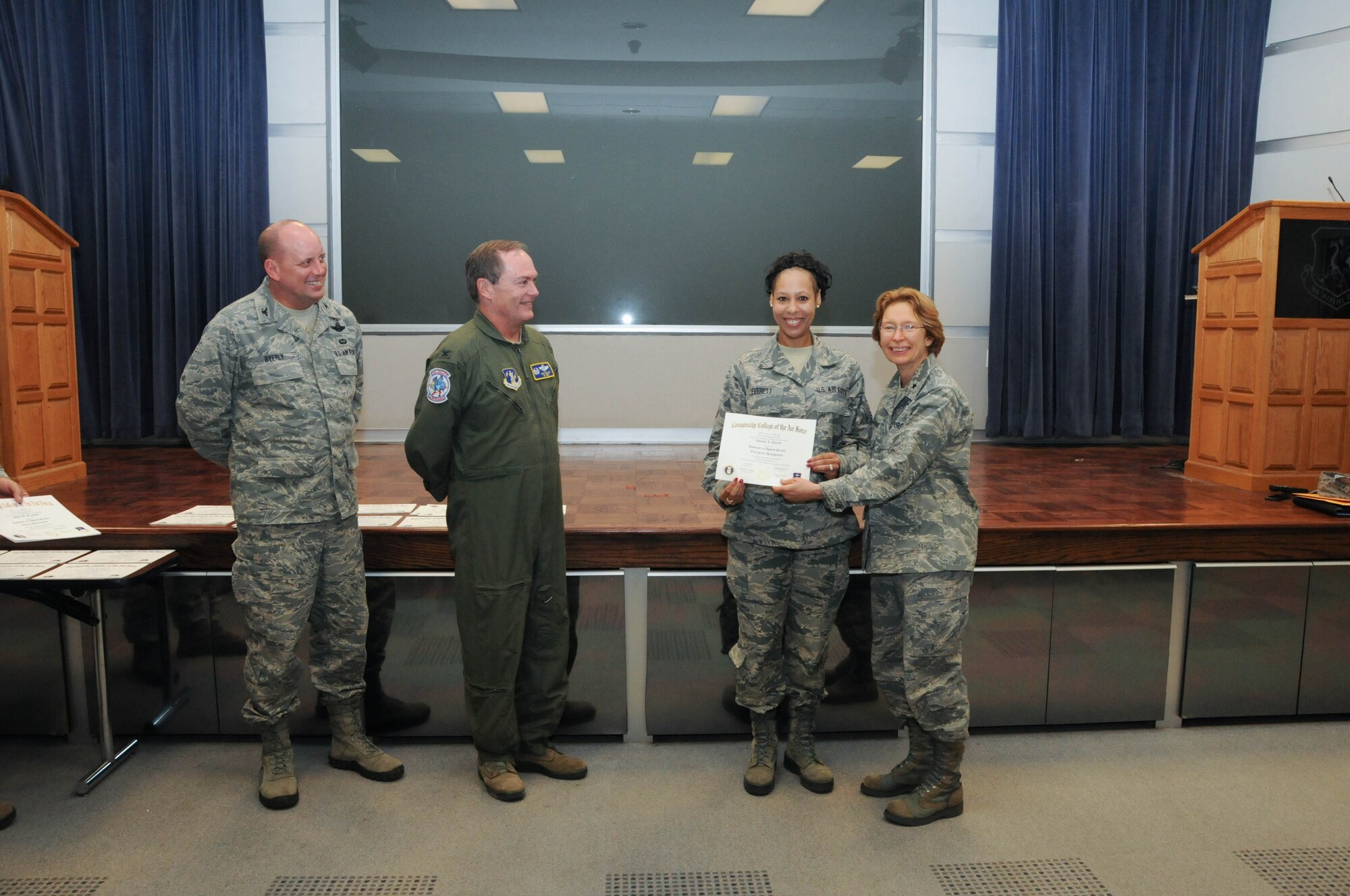 U.S. Air Force Tech. Sgt. Zaquette Everett, second from right, a member of the 166th Airlift Wing, receives a certificate from Brig. Gen. Carol Timmons, assistant adjutant general for air, Delaware National Guard to recognize Everett’s attainment of a Community College of the Air Force associate of applied science degree in vehicle maintenance at a CCAF Class of October 2013 graduation ceremony held Nov. 3, 2013 at the New Castle Air National Guard Base, Del. 166th AW Commander Col. Mike Feeley, second from left, is next to 166th AW Vice-Commander Col. Dave Byerly. (U.S. Air National Guard photo by Tech. Sgt. Robin Meredith)