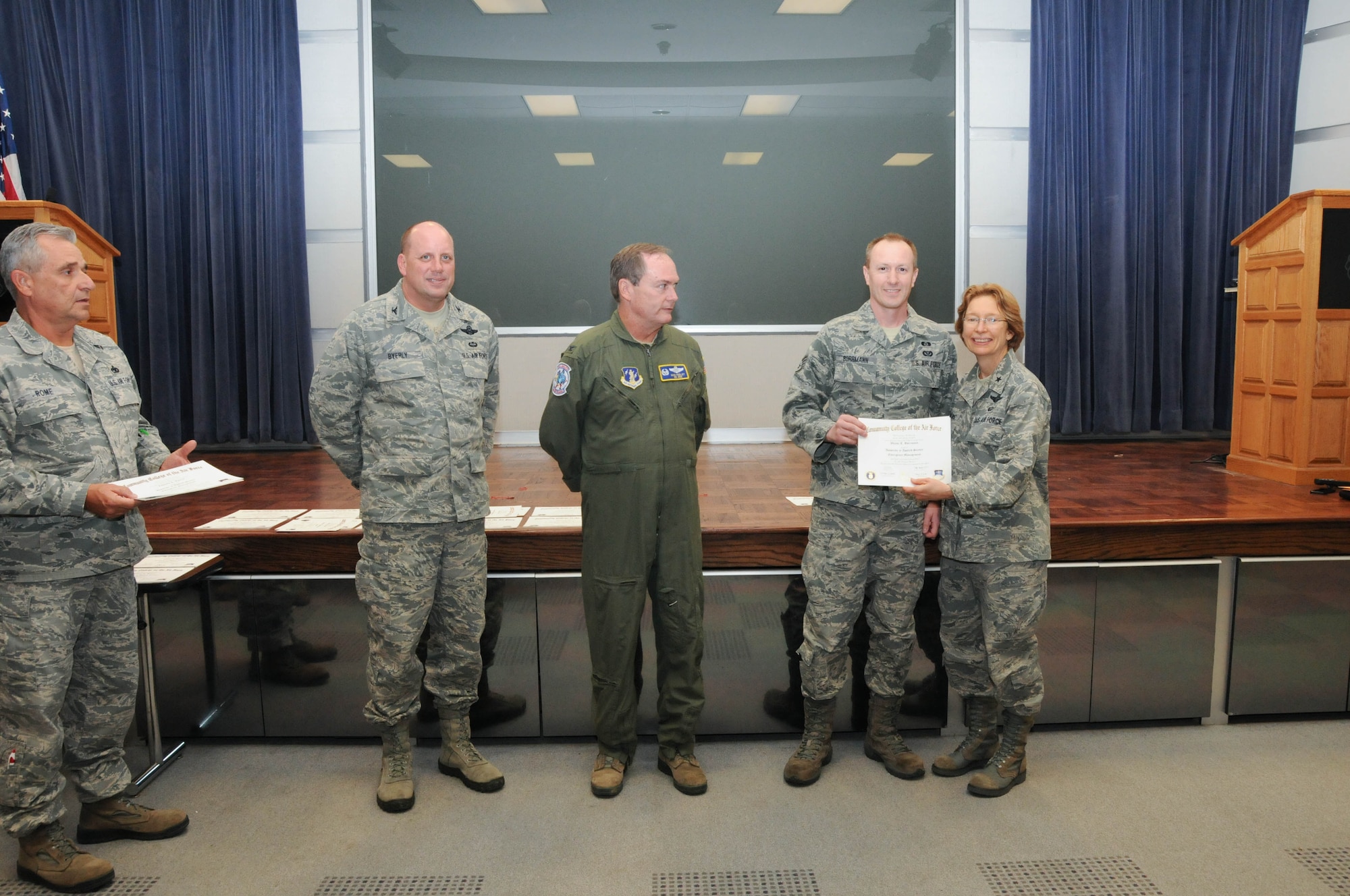 U.S. Air Force Staff Sgt. Wayne Borrmann, second from right, a member of the 166th Civil Engineer Squadron, 166th Airlift Wing, receives a certificate from Brig. Gen. Carol Timmons, assistant adjutant general for air, Delaware National Guard to recognize Borrmann’s attainment of a Community College of the Air Force associate of applied science degree in emergency management at a CCAF Class of October 2013 graduation ceremony held Nov. 3, 2013 at the New Castle Air National Guard Base, Del. 166th AW Commander Col. Mike Feeley, center, is next to 166th AW Vice-Commander Col. Dave Byerly, followed by 166th AW Command Chief Master Sgt. Henry Rome (left). (U.S. Air National Guard photo by Tech. Sgt. Robin Meredith)