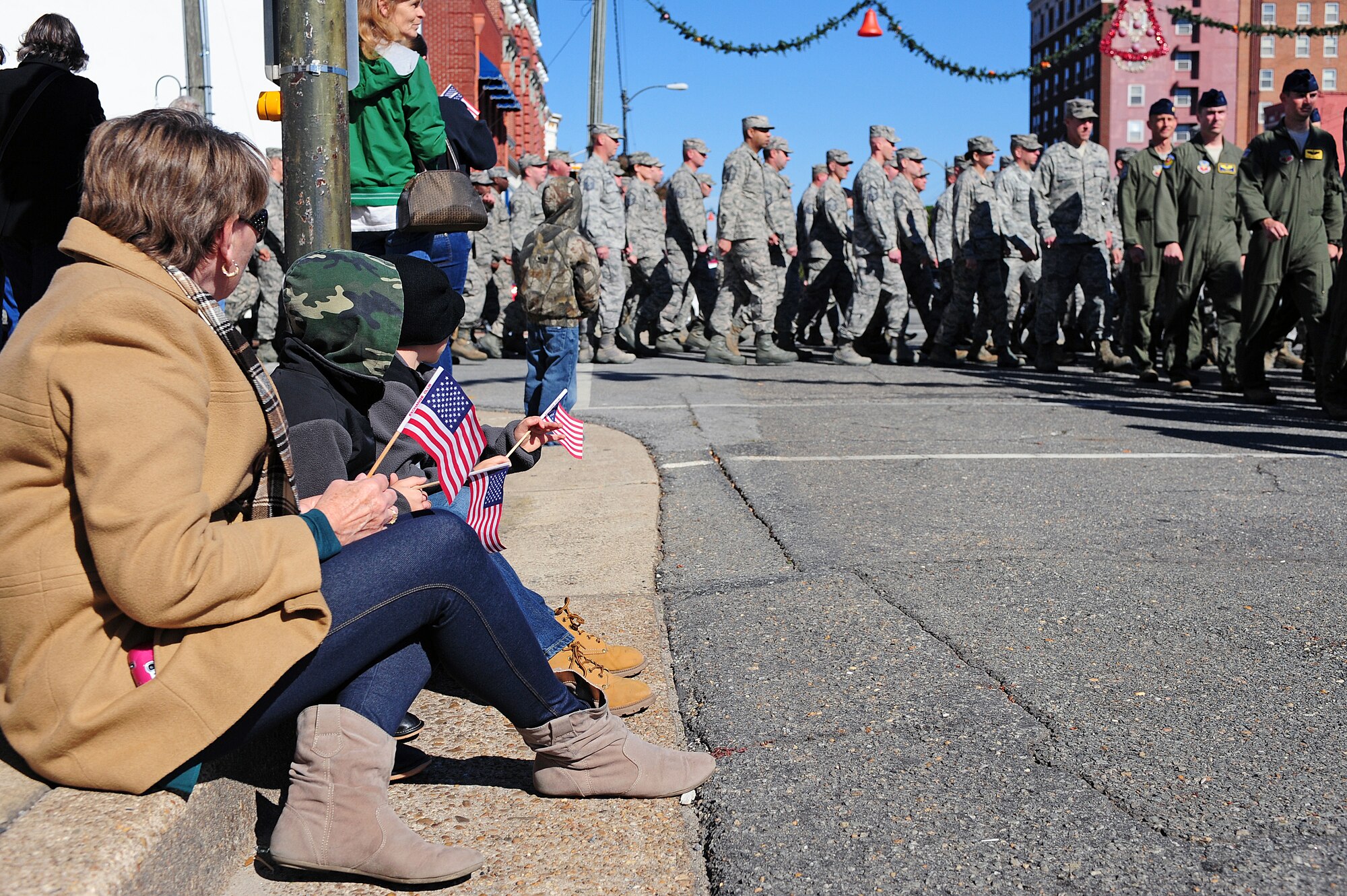 Citizens of Goldsboro, N.C., look on as Airmen assigned to Seymour Johnson Air Force Base march in the 2013 Veterans Day parade in Goldsboro, N.C., Nov. 11, 2013. More than 1,000 people lined the streets to witness the parade and pay tribute to Service members. (U.S. Air Force photo by Airman 1st Class John Nieves Camacho)