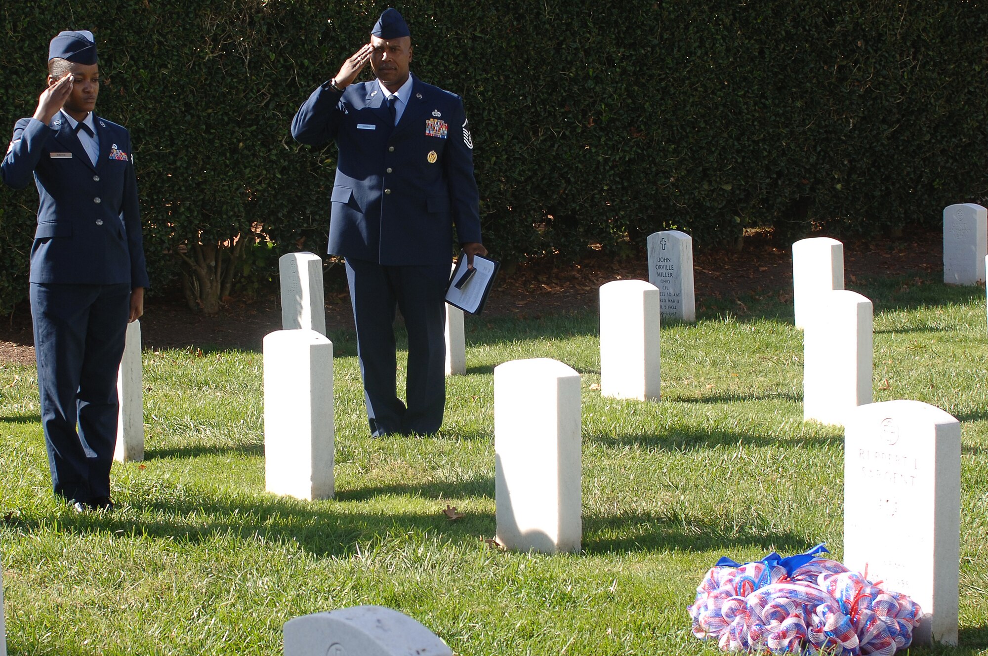 U.S. Air Force Staff Sgt. Melanie Martine, 1st Operations Support Squadron aviation resource manager, and Master Sgt. Alvin Harris, Langley African-American Heritage Council president, render salutes during a wreath-laying ceremony at the Hampton National Cemetery in Hampton, Va., Nov. 11, 2013. The LAAHC hosted the ceremony to honor U.S. Army 1st Lt. Ruppert Sargent, a Medal of Honor recipient who died during the Vietnam War. (U.S. Air Force photo by Senior Airman Teresa Aber/Released)