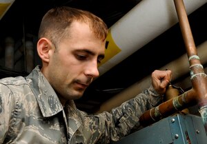 U.S. Air Force Senior Airman Christopher White, 633rd Civil Engineer Squadron heating, ventilation and air conditioning element journeyman, inspects the safety valve of a boiler at Langley Air Force Base, Va., Nov. 8, 2013. The HVAC element oversees operations and repairs to all systems in more than 230 buildings around Langley, ensuring they meet temperature standards to reduce costs. (U.S. Air Force photo by Staff Sgt. Wesley Farnsworth/Released)