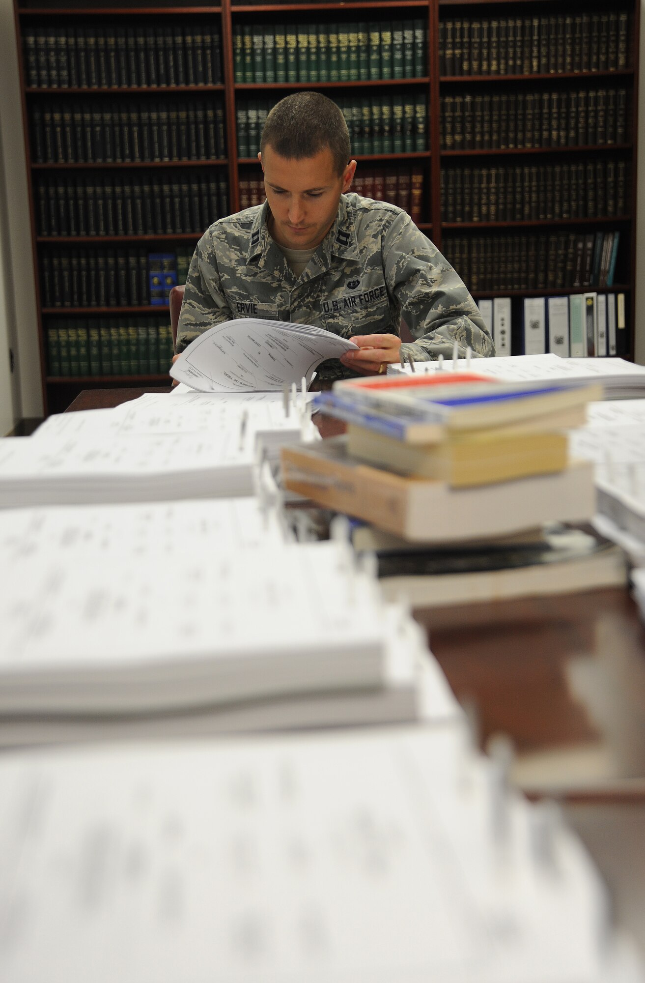 U.S. Air Force Capt. Phillip Ervie, 509th Bomb Wing Judge Advocate chief of adverse actions, reviews a record of trial from a recent court martial at Whiteman Air Force Base, Mo., Oct. 30, 2013. The legal issues military justice professionals encounter are wide-ranging, including criminal, government contract, labor, international, environmental and real property laws. (U.S. Air Force photo by Staff Sgt. Nick Wilson/Released)