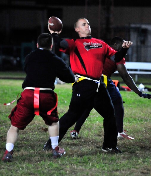 Steven Peaper, 436th Civil Engineer Squadron quarterback, throws a pass as the 436th Maintenance Group/Maintenance Operations Flight tries to defend Nov. 6, 2013, at Dover Air Force Base, Del. Peaper threw three touchdown passes and ran for another score to lead the 436th CES to a 25-6 victory. (U.S. Air Force photo/Tech. Sgt. Chuck Walker)