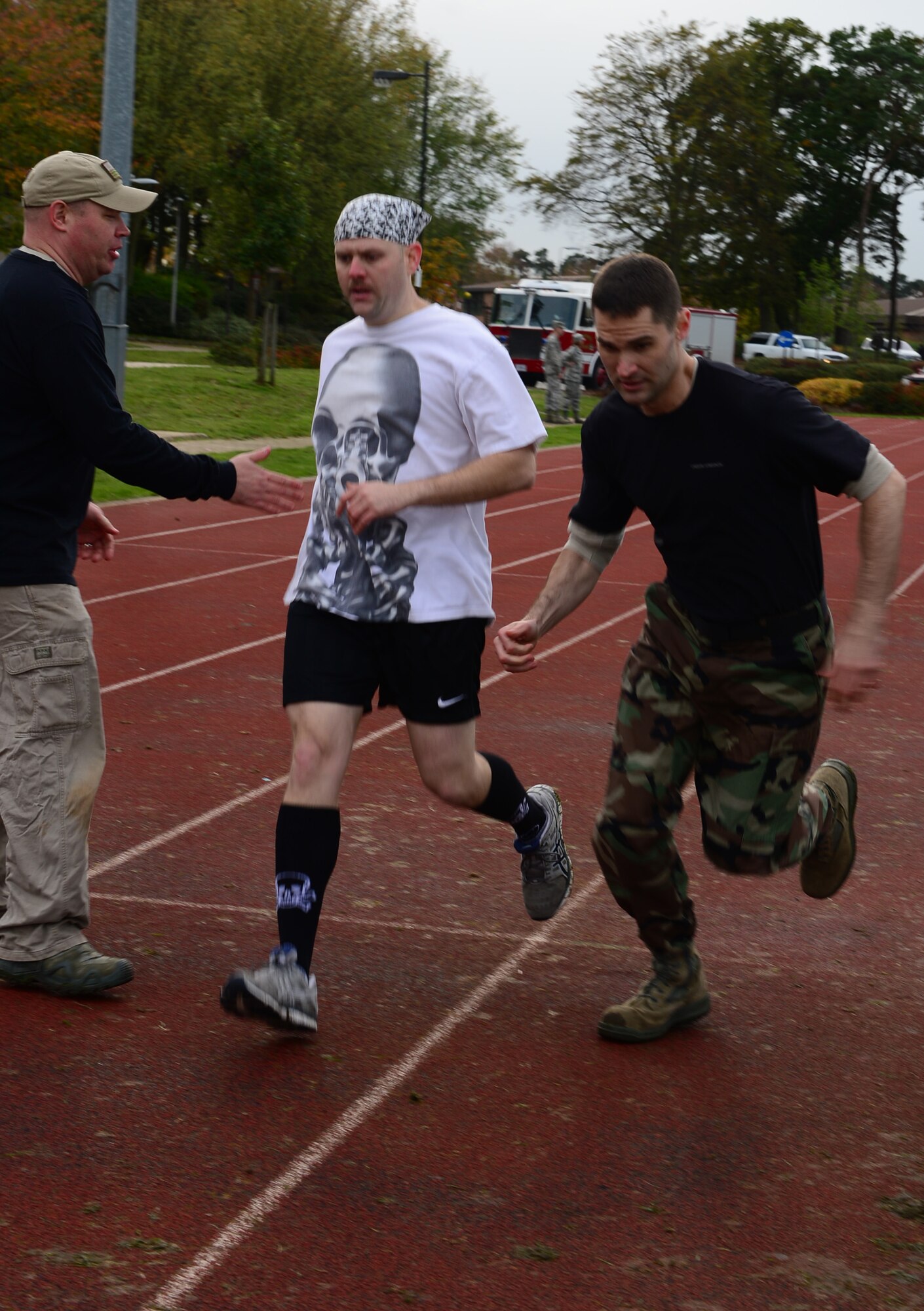Tech. Sgt.William Weisenburg, 48th Medical Surgical Squadron diagnostic imaging craftsman, tags Tech. Sgt. J Hall, 48th MSGS surgical technician, in the one-mile relay race during the joint base Combined Federal Campaign-Overseas Combat Challenge on Royal Air Force Lakenheath, England, Nov. 8, 2013. Airmen from RAFs Lakenheath and Mildenhall competed in the CFC Combat Challenge to help raise money for family support and youth service programs. (U.S. Air Force photo by Airman 1st Class Dawn M. Weber/Released)