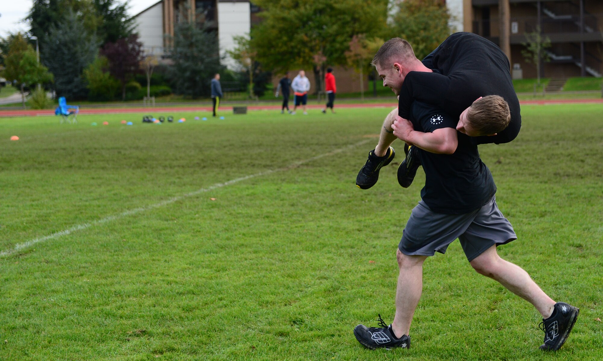 Tech. Sgt. Stephen Sluder, 748th Aircraft Maintenance Squadron section chief, carries Senior Airman Frederick Link, 748th AMXS tactical aircraft crew chief, across the finish line during the joint base Combined Federal Campaign-Overseas Combat Challenge on Royal Air Force Lakenheath, England, Nov. 8, 2013. Twenty teams from RAFs Lakenheath and Mildenhall competed in the CFC Combat Challenge to help raise money for family support and youth service programs. (U.S. Air Force photo by Airman 1st Class Dawn M. Weber/Released)