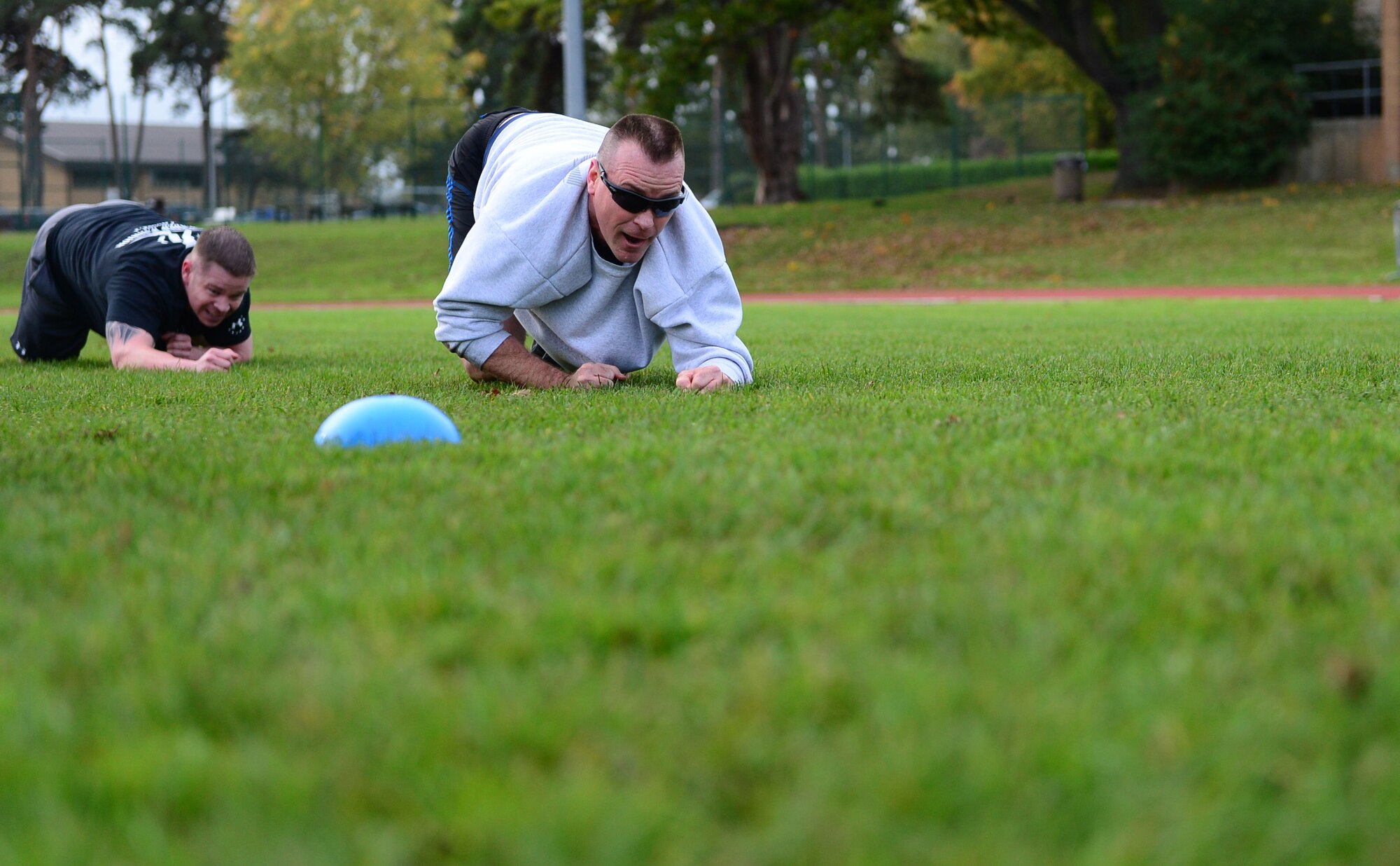 Maj. Jon Mancuso, 748th Aircraft Maintenance Squadron commander, and Tech. Sgt. Stephen Sluder, 748th AMXS section chief, low crawl during the joint base Combined Federal Campaign-Overseas Combat Challenge on Royal Air Force Lakenheath, England, Nov. 8, 2013. Twenty teams from RAFs Lakenheath and Mildenhall competed in the CFC Combat Challenge to help raise money for family support and youth service programs. (U.S. Air Force photo by Airman 1st Class Dawn M. Weber/Released) 
