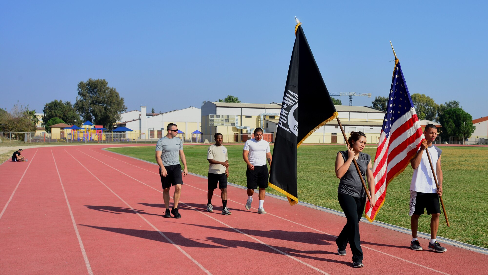 A group of Airmen transfer the American and POW flags to the next set of runners during the 24-hour POW/MIA walk and run Nov. 11, 2013, at Incirlik Air Base, Turkey. More than 200 members of the 39th Air Base Wing ran with the POW/MIA flag for cumulative amount of more than 640 miles In remembrance of those who went missing in action or became prisoners of war. (U.S. Air Force photo by Staff Sgt. Eric Summers Jr.)
