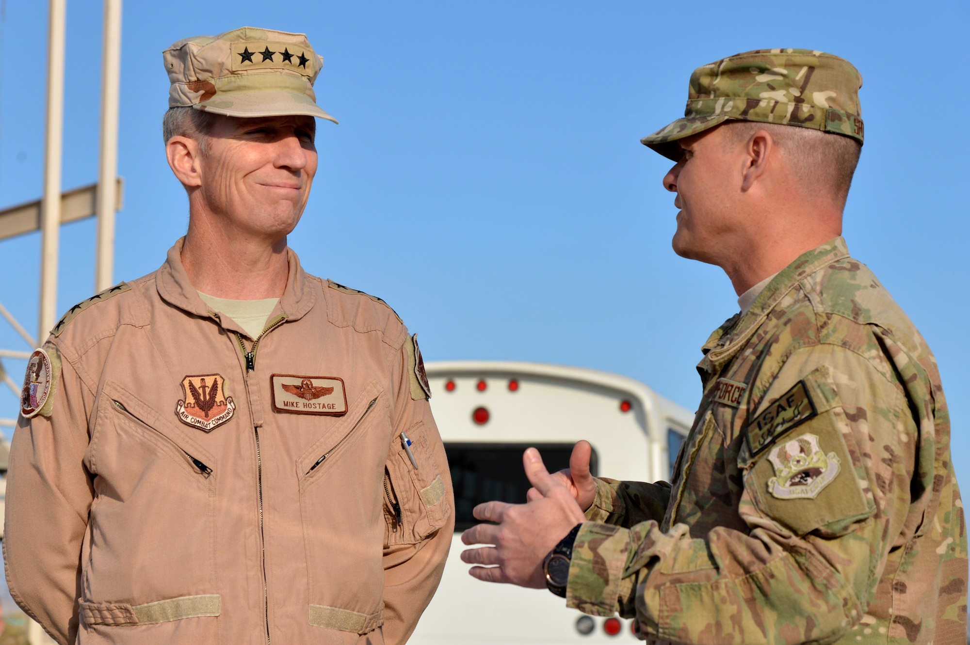 U.S. Air Force Gen. Mike Hostage, commander of Air Combat Command, speaks with Maj. Michael Speck, 455th Expeditionary Base Defense Squadron commander, during a base tour at Bagram Airfield, Afghanistan, Nov. 9, 2013. During the first of the two days he spent at BAF, Hostage toured six different areas and gained a better understanding of expectations and requirements and also addressed concerns of deployed Airmen. (U.S. Air Force photo by Senior Airman Kayla Newman/Released)
