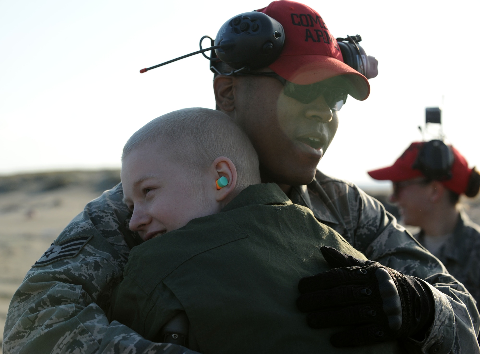 Staff Sgt. Quentin Gray, 35th Security Forces Squadron combat arms instructor, receives a hug from 17-year-old Jonah Skrove at Draughon Range near Misawa Air Base, Japan, Nov. 1, 2013. The Make-A-Wish Foundation sponsored Jonah, his parents and sister on a trip here to visit his older brother, and several base agencies allowed the Skrove family to tour their facilities. In thanks, more than 30 Airmen received a hug from Jonah. (U.S. Air Force photo by Staff Sgt. Alyssa C. Wallace/released)