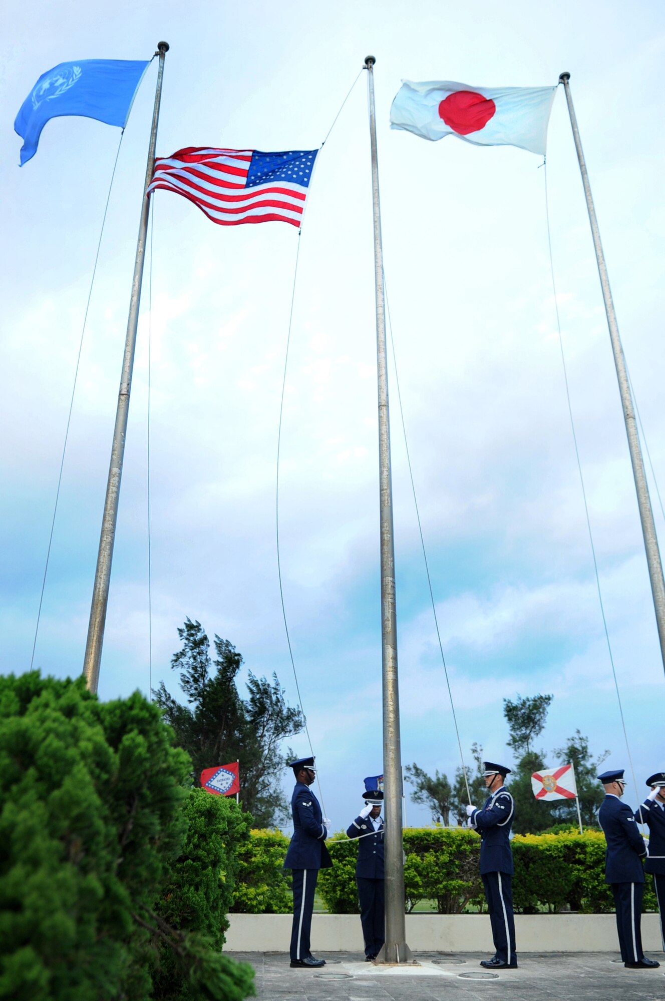 Members of the Kadena Honor Guard raise the NATO, American and Japanese flags during reveille at a Veterans Day ceremony on Kadena Air Base, Japan, Nov. 11, 2013. Following reveille and the Japanese and American national anthems, each military branch recited their creed in honor of those who have served in the United States military. (U.S. Air Force photo by Staff Sgt. Amber E. N. Jacobs)
