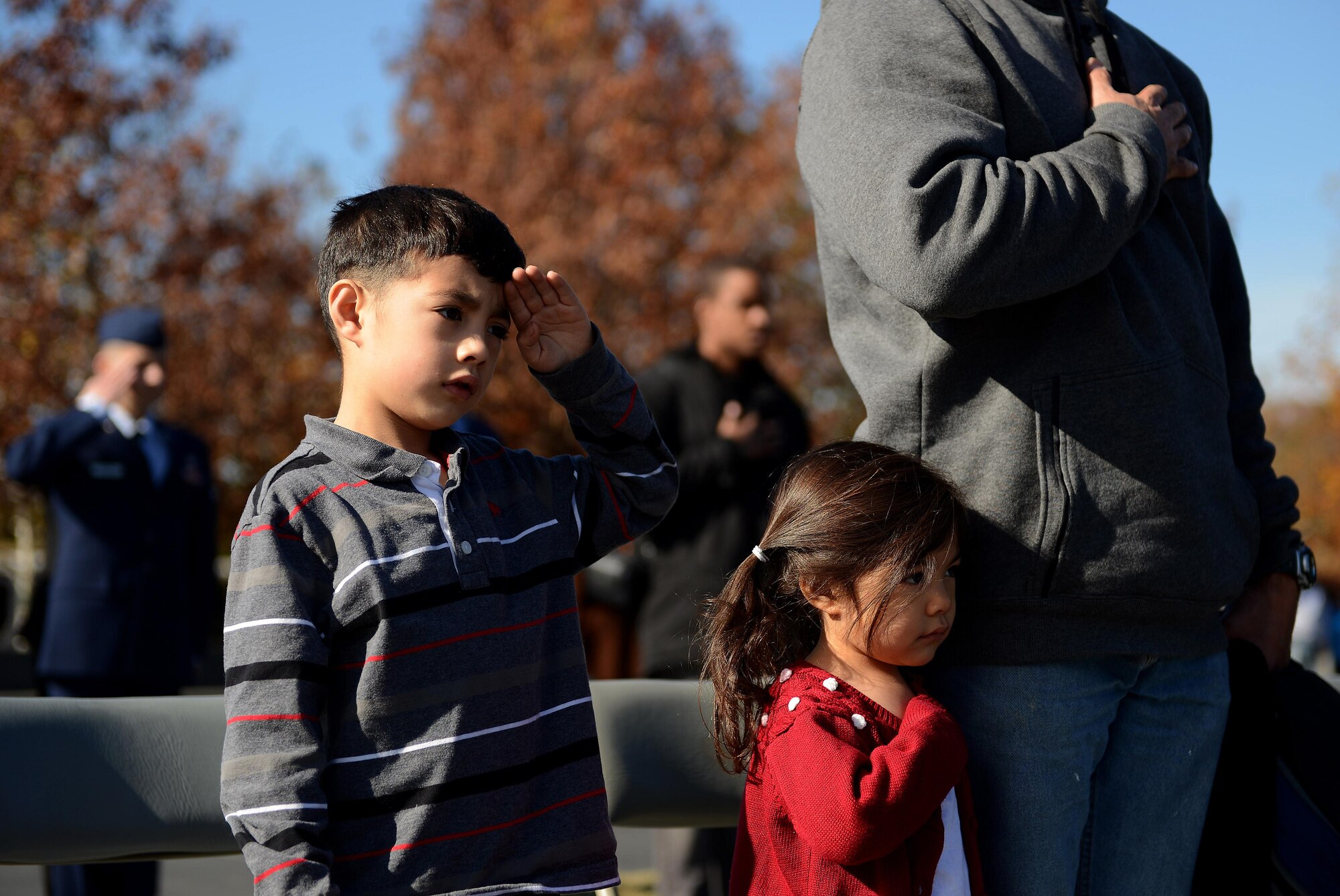 Michael Eloy, 5, (from left) Kimiko Eloy, 3, and their father, Army Maj. Cabera Eloy salute as the colors are presented during a Veterans Day wreath laying ceremony at the Air Force Memorial, Arlington, Va., Nov. 11, 2013. More than 100 veterans, service members, family members and supporters came out for the wreath laying ceremony. 