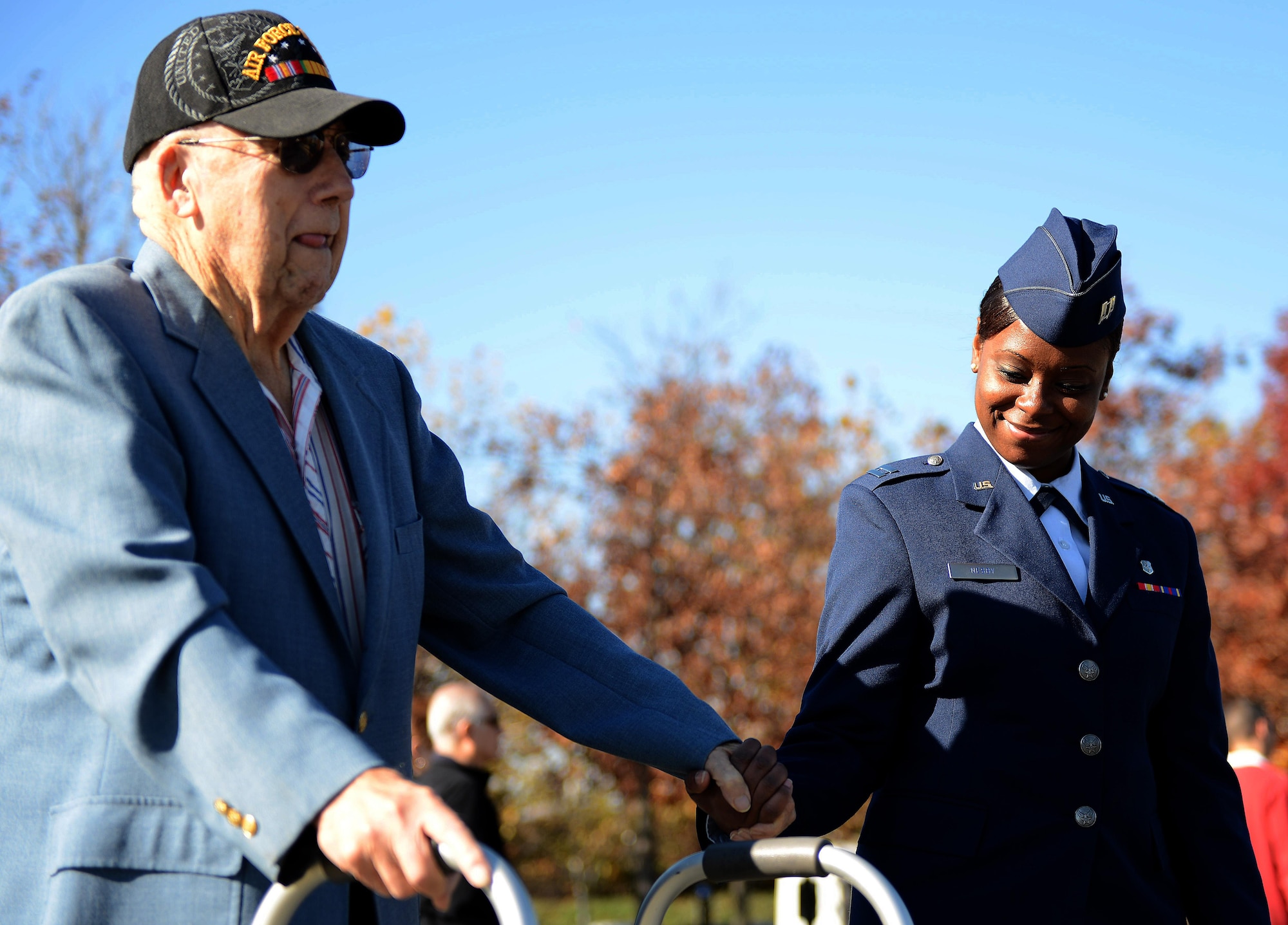 Capt. Natosha Nesby, 779th Medical Operations Squadron, Andrews Air Force Base, Md., escorts an Air Force veteran during a  Veterans Day wreath laying ceremony, Nov. 11, 2013 at the Air Force Memorial in Arlington, Va. More than 100 veterans, service members, family members and supporters came out for the ceremony.