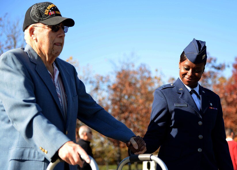 Capt. Natosha Nesby, 779th Medical Operations Squadron, Andrews Air Force Base, Md., escorts an Air Force veteran during a  Veterans Day wreath laying ceremony, Nov. 11, 2013 at the Air Force Memorial in Arlington, Va. More than 100 veterans, service members, family members and supporters came out for the ceremony.