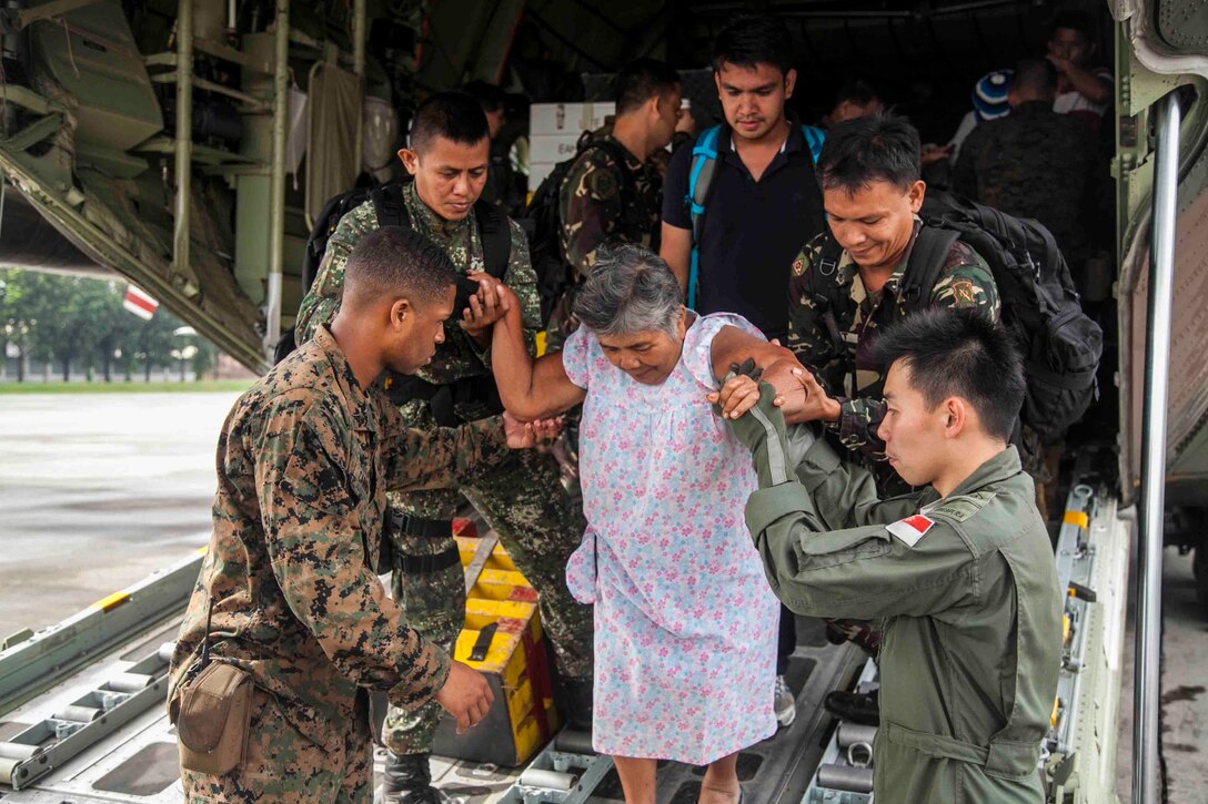 U.S. Marine Lance Cpl. Xavier L. Cannon and members of the Philippine Armed Forces assist civilians off of a C-130 aircraft Nov. 13 at Villamor Air Base as part of Operation Damayan. Typhoon Haiyan impacted more than 4.2 million people across 36 provinces in the Philippines, according to the Philippine government’s National Disaster Risk Reduction and Management Council. The Marines are with the 3rd Marine Expeditionary Brigade, III Marine Expeditionary Force. (U.S. Marine Corps photo by Lance Cpl. Anne K. Henry/RELEASED)

