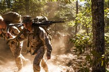 Virginia Beach, Va (Sept. 27, 2013) - Staff Sgt. Dennis Dodge, watch officer, Headquarters and Service Battalion, U.S. Marine Corps Forces Command, charges a hill carrying an M240G medium machine gun during a conditioning hike aboard Joint Expeditionary Base Little Creek, Fort Story Sept. 27. The evolution was designed to test the unit's combat readiness and The Marines followed up the hike with values based training before they were bussed back to Camp Allen for additional moral builders: barbeque and games.