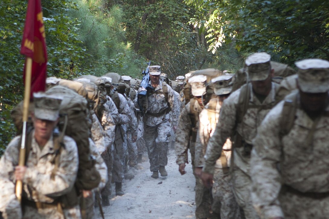 Virginia Beach, Va (Sept. 27, 2013) - Col. Paul Ryan, commanding officer, Headquarters and Service Battalion, U.S. Marine Corps Forces Commnad, carries an M240G medium machine gun up the tactical column during a six-mile conditioning hike aboard Joint Expeditionary Base Little Creek, Fort Story Sept. 27. The hike was designed to test the unit's combat readiness and build unit cohesiveness and morale.