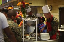 Sgt. Maj. George W. Young Jr. (right), the sergeant major of 2nd Marine Logistics Group, dishes up food for service members and their family and friends aboard Camp Lejeune, N.C., Nov. 7, 2013. Young, along with other command staff from around 2nd MLG, served lunch during a Marine Corps birthday celebration held at the messhall. 