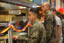 Service members wait in line for food being served by the senior officers and enlisted leaders of the various units of 2nd Marine Logistics Group aboard Camp Lejeune, N.C., Nov. 7, 2013. The senior leadership of 2nd MLG served lunch at the messhall to commemorate the 238th birthday of the Marine Corps. 