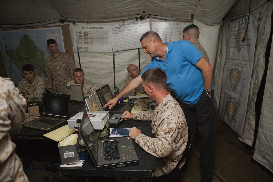Dave Bryan (right), Marine Air Ground Task Force Integrated Systems Training Center Hawaii command operations center specialist and instructor, and 46-year-old native of Terre Hill, Penn., offers guidance to a Marine with 1st Battalion, 3rd Marine Regiment during a weeklong simulated training exercise outside the MISTC Hawaii building aboard Marine Corps Base Hawaii, Nov. 1, 2013. The training helped Marines become more familiar with processes regarding information being sent from the combat operations center to units in the field. (U.S. Marine Corps photo by Lance Cpl. Matthew Bragg)