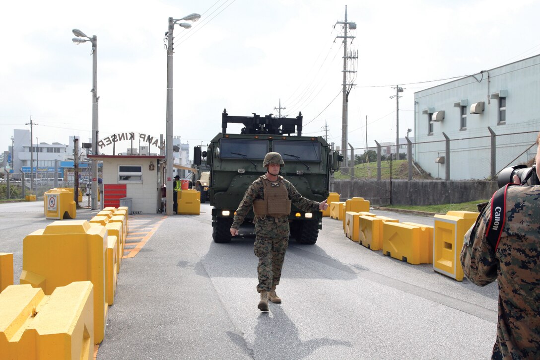 Brig. Gen. Steven R. Rudder guides a Logistics Vehicle System Replacement through a gate at Camp Kinser Nov. 6 during a visit with Motor Transport Company. During the visit, Rudder performed the duties of an assistant driver in the LSVR from Camp Foster to Camp Kinser, to include monitoring blind spots and navigating; gaining a better understanding of the safety procedures associated with the vehicle. Rudder is the commanding general of 1st Marine Aircraft Wing, III Marine Expeditionary Force, and Motor Transport Co. is with Marine Wing Support Squadron 172, Marine Aircraft Group 36, 1st MAW, III MEF. (U.S. Marine Corps photo by Lance Cpl. David N. Hersey/Released)