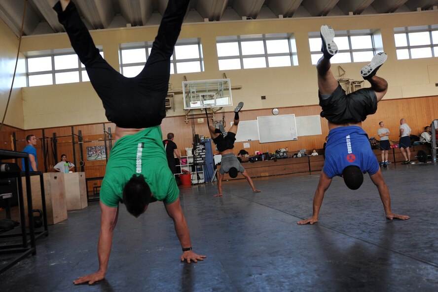 Airmen from Misawa Air Base, Japan, perform handstand walks during a cross-training workout at the base fitness center Nov.5, 2013. Around 100 Airmen take part in five daily classes that focus on aspects of all-around fitness. (U.S. Air Force photo by Senior Airman Derek VanHorn)