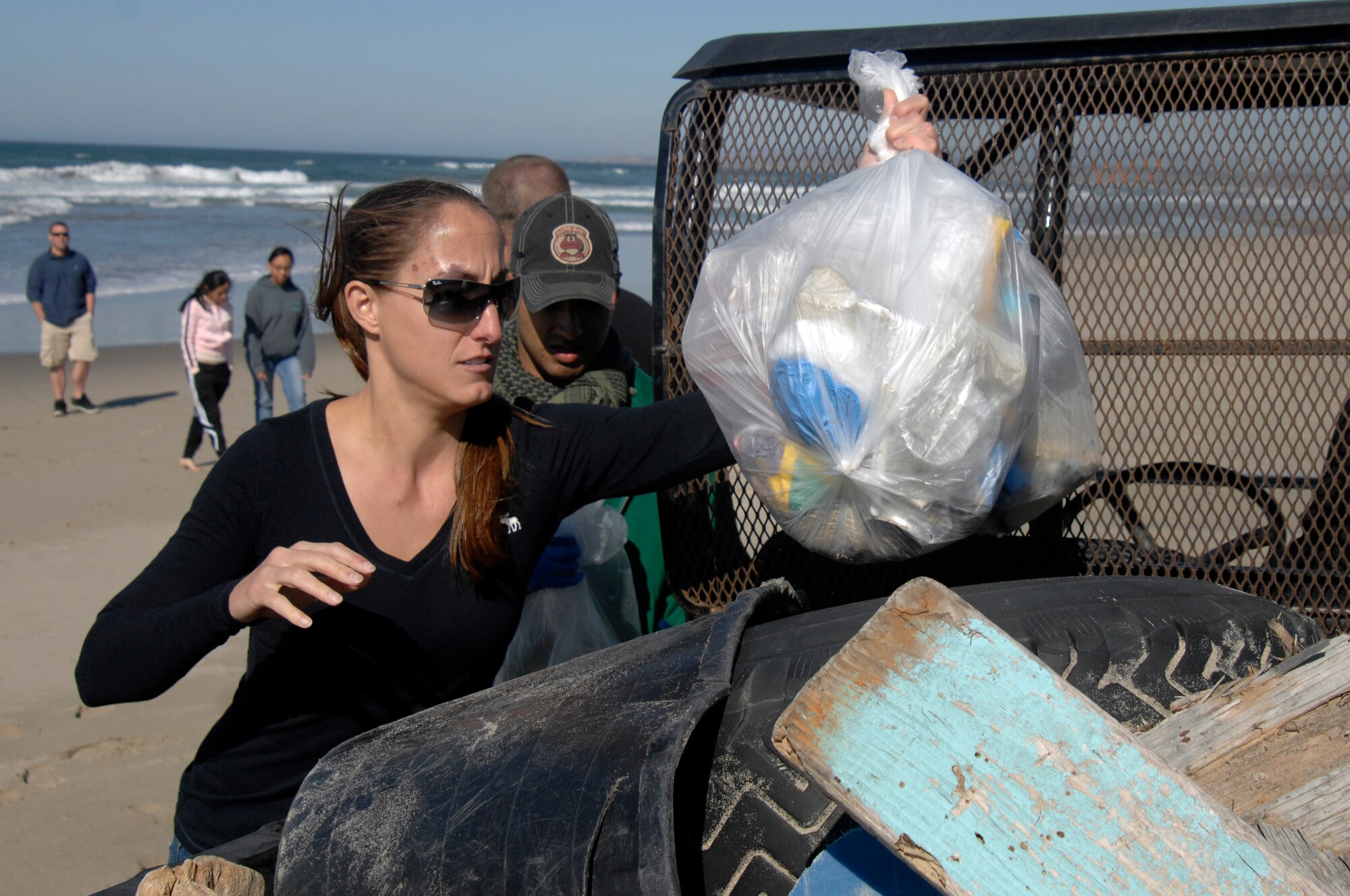 VANDENBERG AIR FORCE BASE, Calif. -- Staff Sgt. Lara Nottingham, 9th Space Operations Squadron member and volunteer, loads a bag of collected trash onto a pickup vehicle during Beach Cleanup Day here Wednesday, Nov. 13. (U.S. Air Force photo/Michael Peterson).