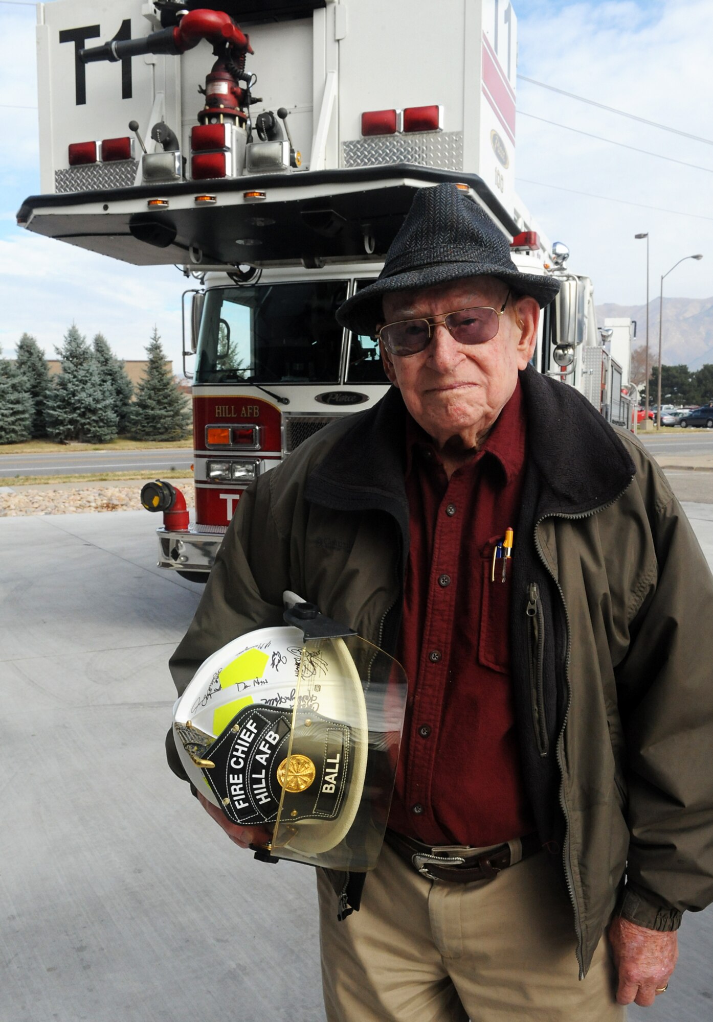 Shirley Leroy Ball of Kaysville, Utah, poses in front of  a fire truck Nov. 13 at Hill Air Force Base following a ceremony to recognize him as Hill’s first ever “Honorary Fire Chief.” Ball, a retired Hill firefighter of 31 years, also celebrated his 100th birthday and was honored for his decades of support to the base’s fire department. (U.S. Air Force photo by Alex R. Lloyd/Released)