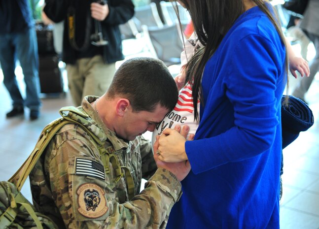 Senior Airman Joseph Tharp, 9th Operations Support Squadron flight equipment technician, hugs his pregnant wife Sarah Nov. 7, 2013, at Sacramento International Airport. Tharp was returning home from a deployment to Afghanistan. (U.S. Air Force photo by Airman 1st Class Bobby Cummings/Released)