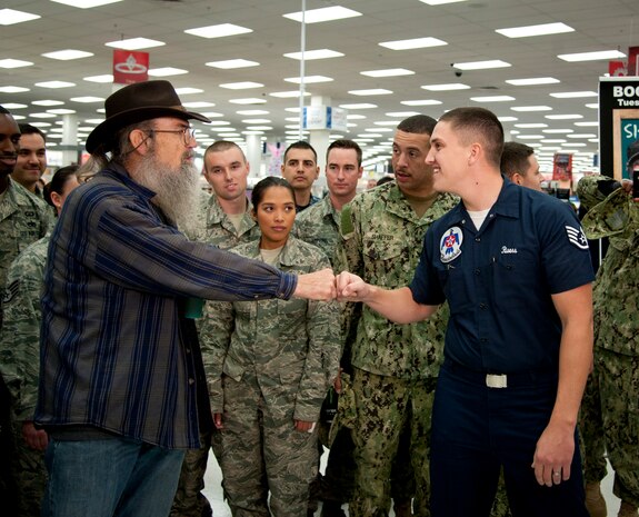 Staff Sgt. Ryan Rivers, U.S. Air Force Air Demonstration Squadron “Thunderbirds” aircraft structural maintenance technician, fist-bumps Si Robertson, Duck Dynasty star, after presenting him with a unit coin at the Exchange Nov. 12, 2013, at Nellis Air Force Base, Nev. Many fans brought gifts such as coins and other mementos to give to Si at his book signing appearance. (U.S. Air Force photo by Master Sgt. Jason W. Edwards)