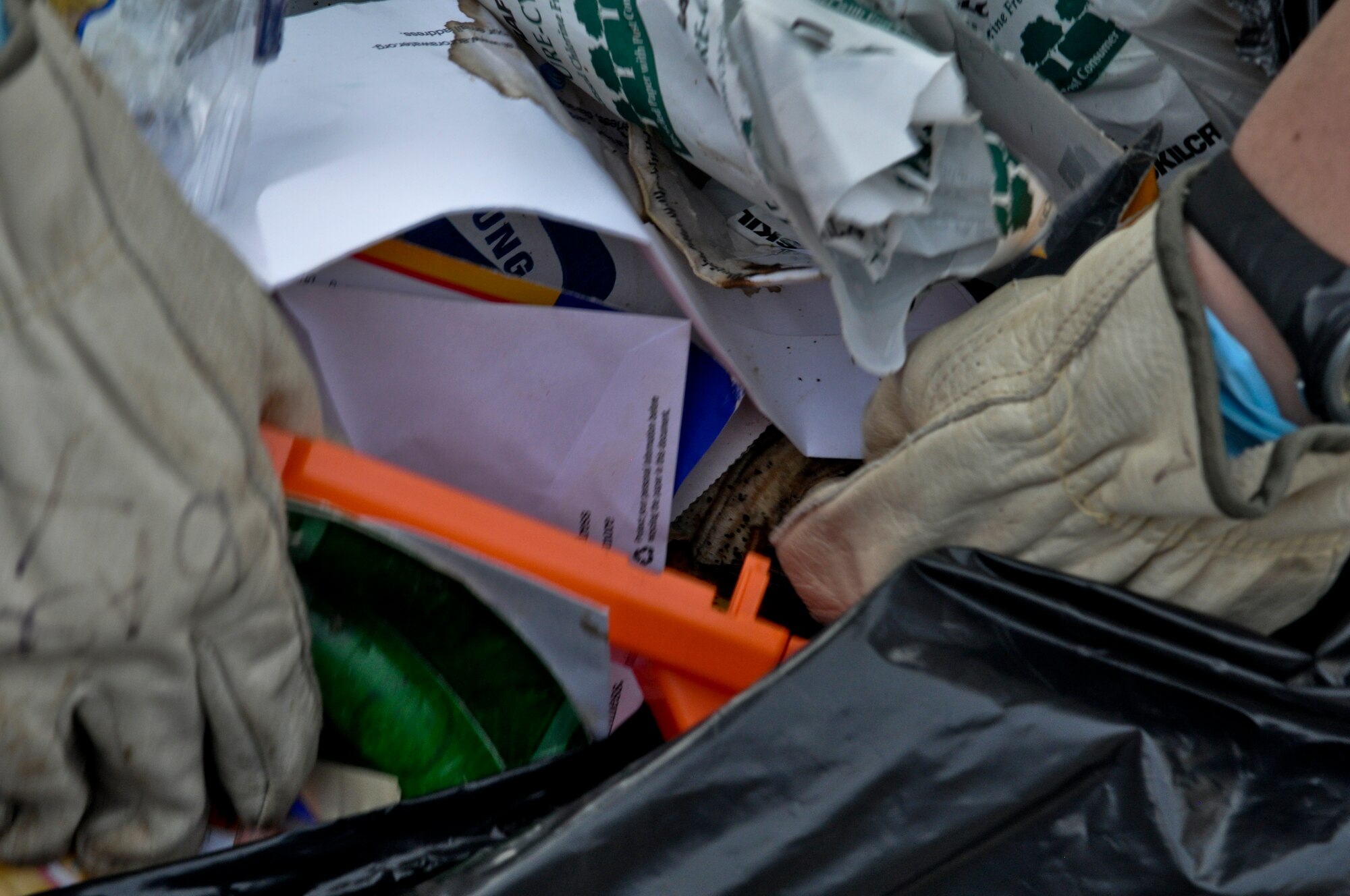 1st Lt. Liz Dunsworth, 460th Space Wing Plans and Programs office chief Crisis Action Team director, searches through garbage for non-shredded documents Nov. 8, 2013, on Buckley Air Force Base, Colo.  This search was part of an ongoing project ensuring the base is following all operations security measures and preventing unauthorized access to secret and personal information. (U.S. Air Force photo by Staff Sgt. Nicholas Rau/Released)