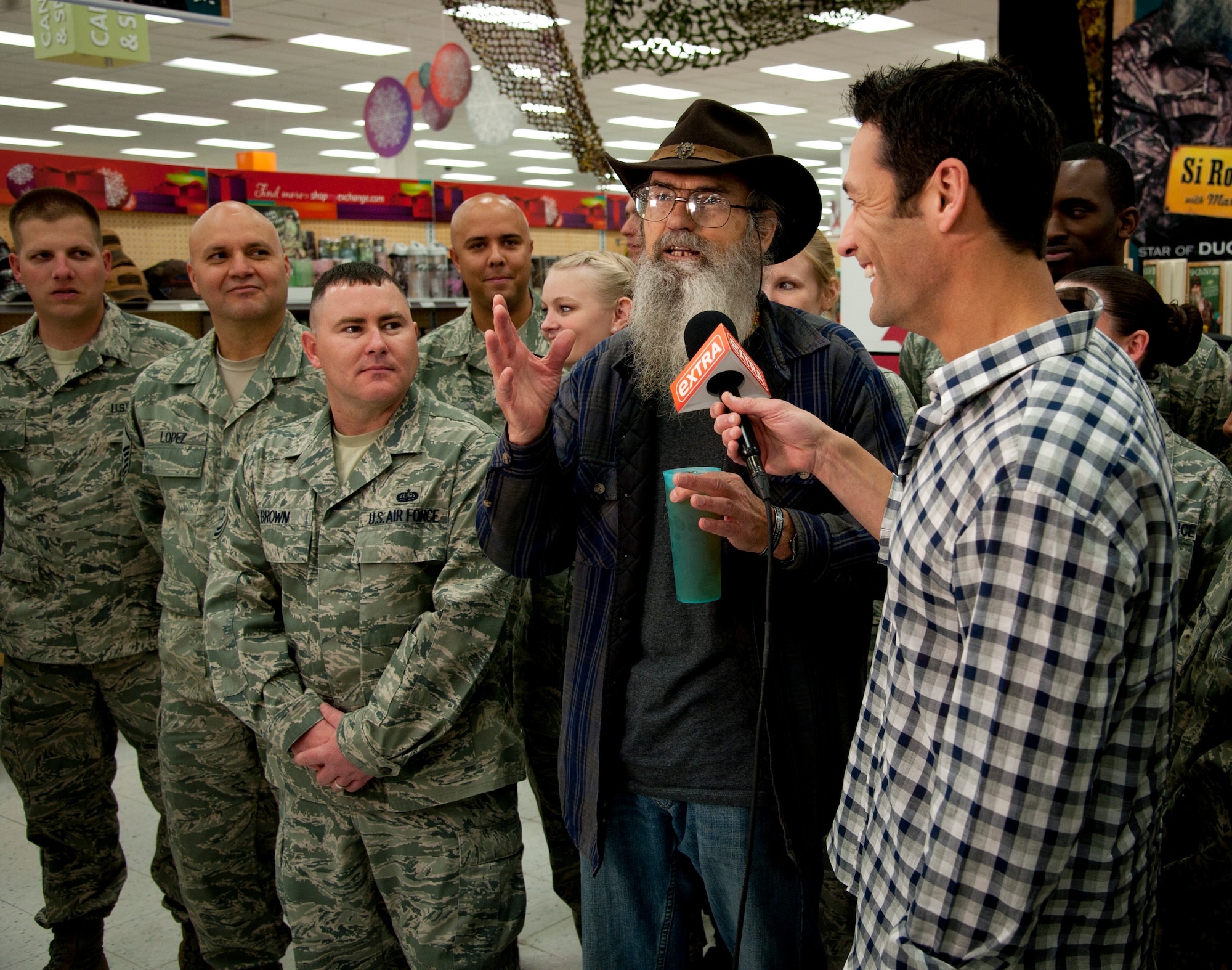 Nellis Air Force Base, Nev., Airmen look on as Jason Feinberg, FOX5 correspondent, interviews Duck Dynasty star, Si Robertson, at the Exchange Nov. 12, 2013, at Nellis AFB. Robertson was on-hand to meet with fans and sign copies of his book, “Si-cology 1: Tales and Wisdom from Duck Dynasty’s Favorite Uncle.” (U.S. Air Force photo by Master Sgt. Jason W. Edwards)

