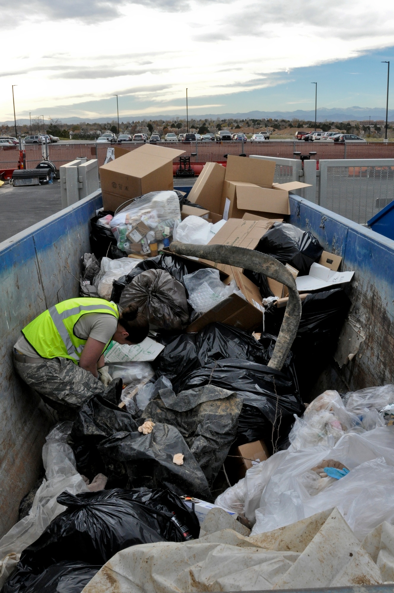 1st Lt. Liz Dunsworth, 460th Space Wing Plans and Programs office chief Crisis Action Team director, sifts through the trash looking for non-shredded documents Nov. 8, 2013, on Buckley Air Force Base, Colo. This search was part of an ongoing initiative to guarantee the base 100-percent shred policy is followed. (U.S. Air Force photo by Staff Sgt. Nicholas Rau/Released)