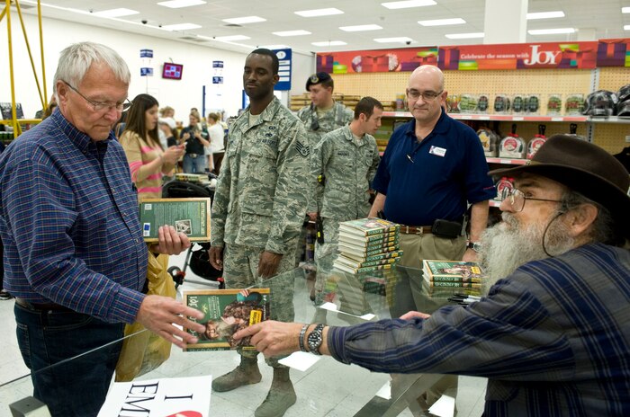 Bob Turner, Air Force Center for Environmental Excellence natural resource manager, gets the book “Si-cology 1: Tales and Wisdom from Duck Dynasty's Favorite Uncle” signed by Si Robertson, Duck Dynasty Star, during his book signing at the Exchange Nov. 12, 2013, at Nellis Air Force Base, Nev. Robertson's book is about his life and family experiences. (U.S. Air Force photo by Senior Airman Matthew Lancaster)
