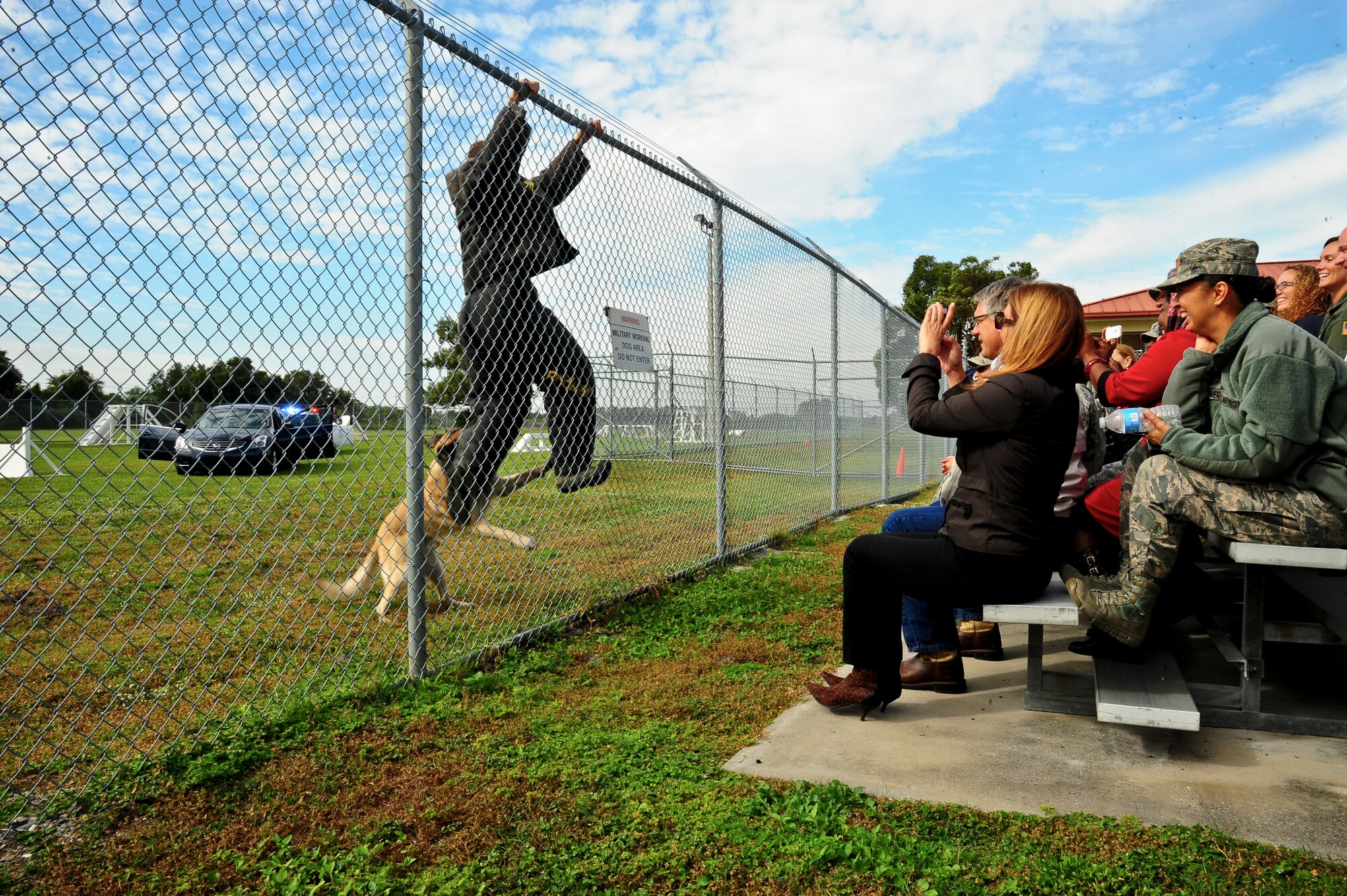 Participants in Operation Partnership watch a military working dog demonstration at MacDill Air Force Base, Fla., Nov. 13, 2013. Members of the 6th Security Forces Squadron MWD did multiple demonstrations, answered questions and gave a walkthrough of the facility. (U.S. Air Force photo by Airman 1st Class Ned T. Johnston/Released)