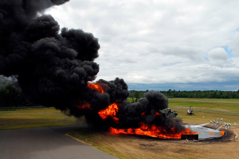 Firefighters move in to attack a JP-8 fire during joint Air Force and Army training at the 2013 Warrior Exercise in late July.  Approximately 14 919th Special Operations Wing firefighters supported the exercise and received their annual fire training while there.  (Courtesy photo)