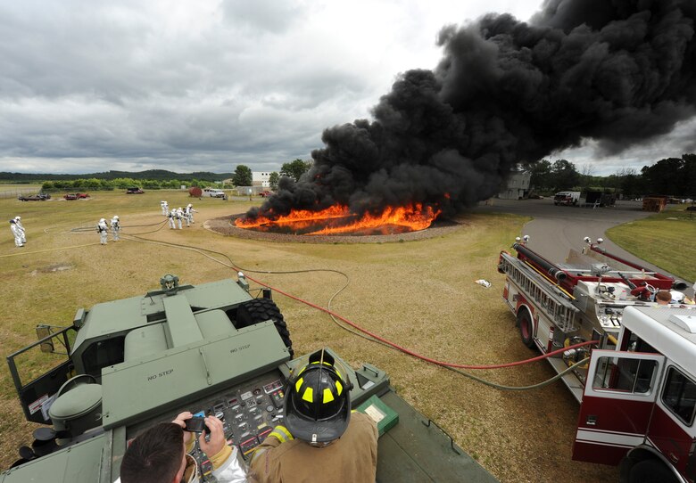 Firefighters wait to attack a JP-8 fire during joint Air Force and Army training at the 2013 Warrior Exercise in late July.  Approximately 14 919th Special Operations Wing firefighters supported the exercise and received their annual fire training while there. (U.S. Air Force photo/Staff Sgt. Jared Becker)