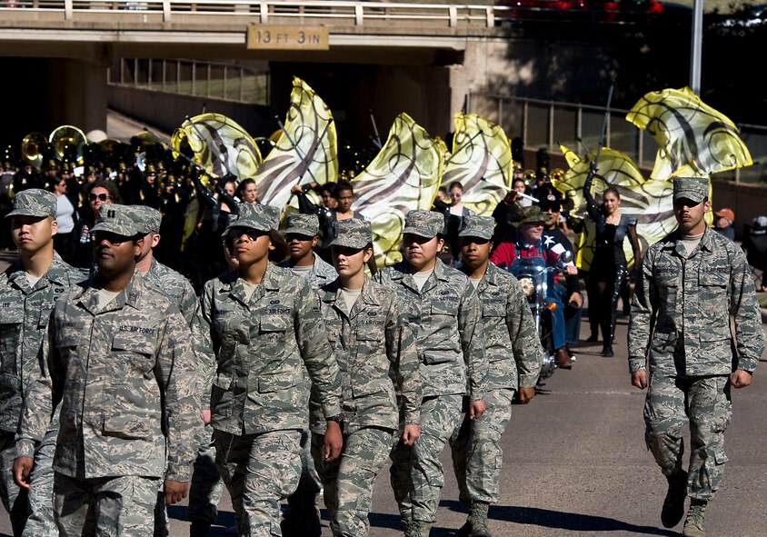 Airmen from the 7th Bomb Wing march in front of the Abilene High School marching band during the annual Veteran’s Day parade Nov. 9, 2013, in downtown Abilene, Texas. This year the parade was dedicated in memory of Abilene’s former Fire Chief Gerald Garrett. Retired Tech. Sgt. Garrett took part in organizing the annual Abilene Veteran’s Day parade for the past 13 years. (U.S. Air Force photo by Senior Airman Peter Thompson/Released)