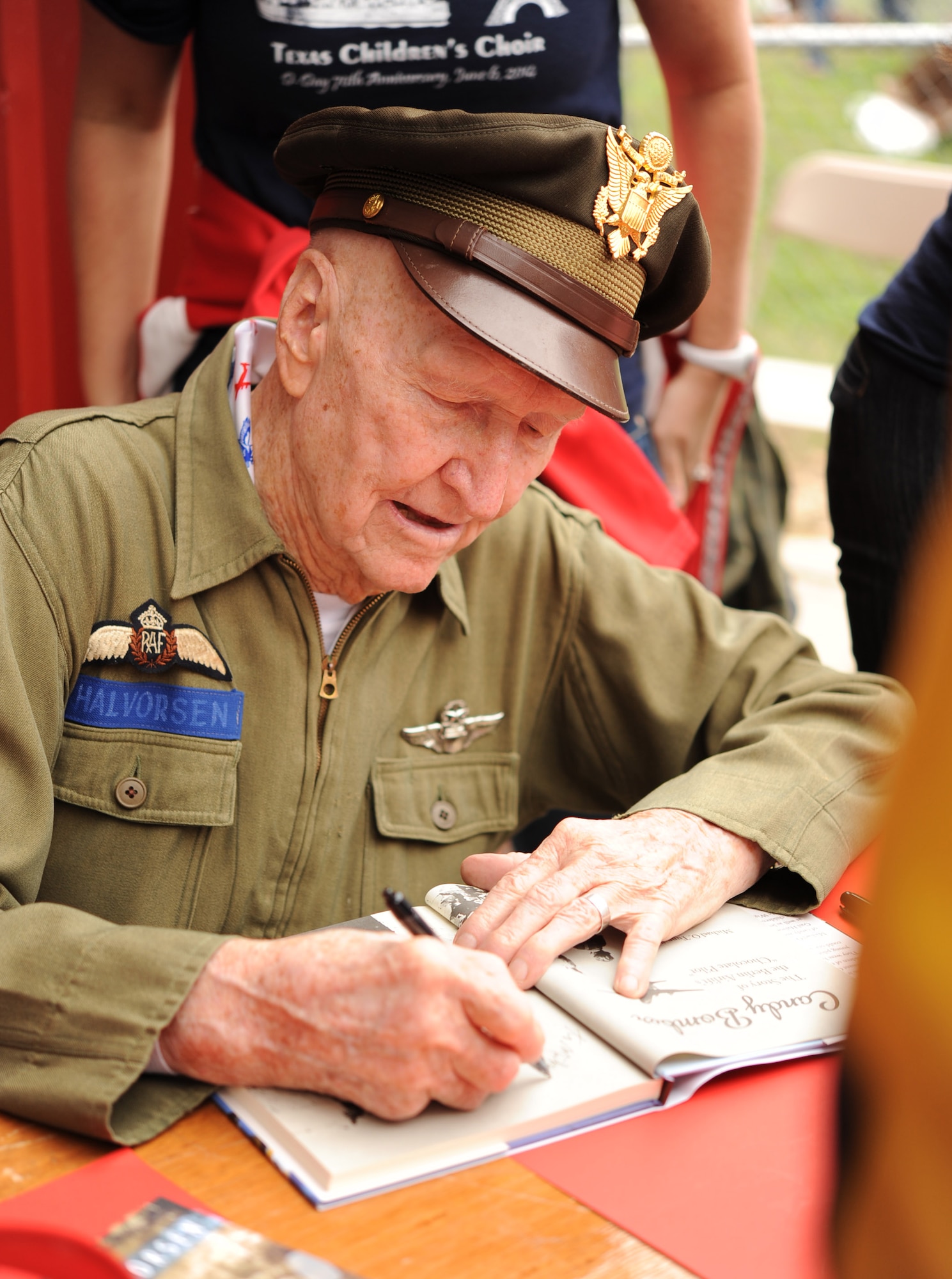 Retired Air Force Col. Gail Halvorsen signs autographs Nov. 9 at the South Texas Regional Airport, Hondo, Texas. Halvorsen participated in a re-enactment of Operation Little Vittles that took place during the Berlin Airlift, following WWII. Halvorsen and his crew dropped about 2,000 candy bars from a vintage C-47 Skytrain during the event. (U.S. Air Force photo/Staff Sgt. Jerilyn Quintanilla)