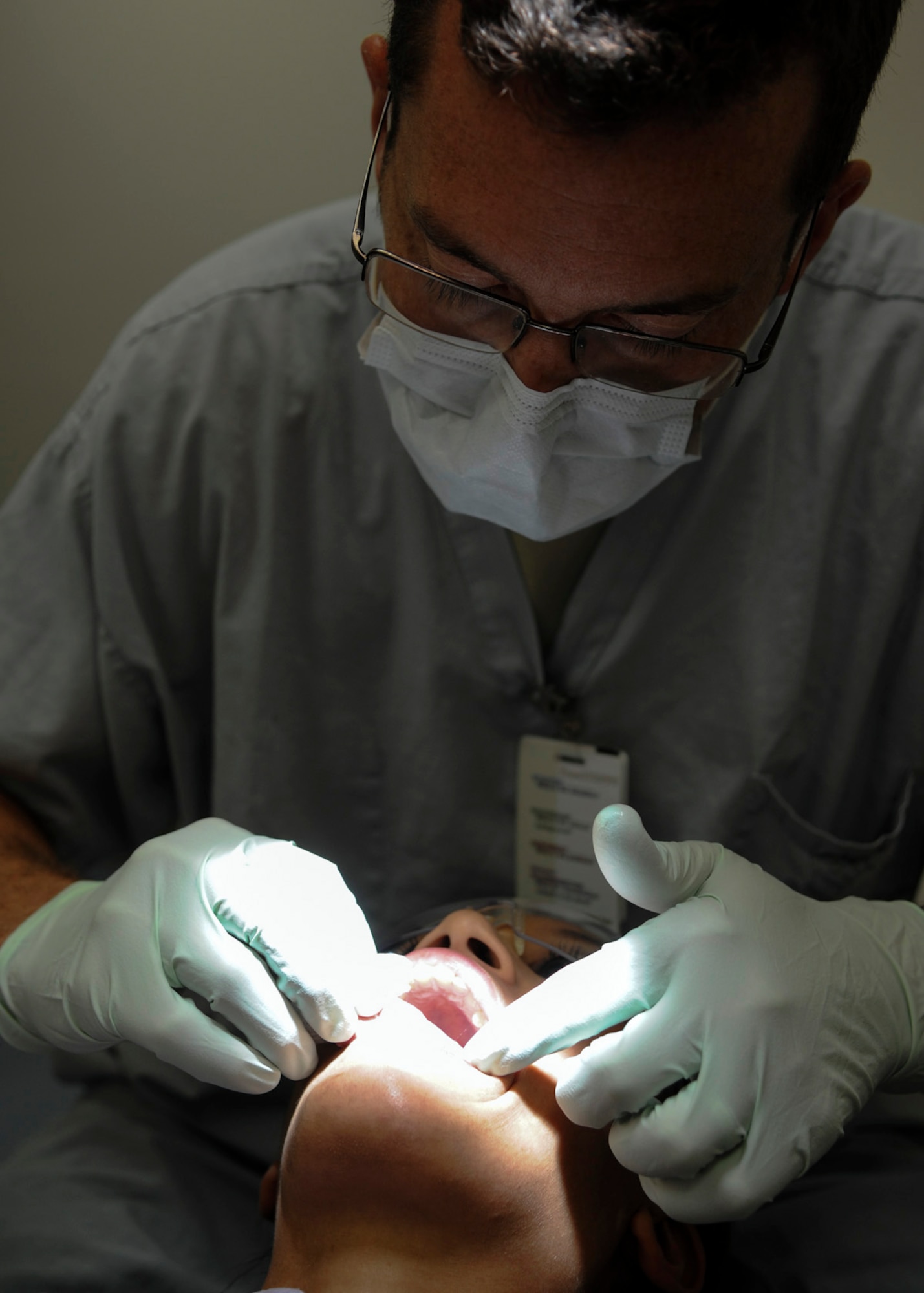U.S. Air Force Capt. Riley Adams, a general dentist with the 59th Dental Squadron, examines Senior Airman Sherree Skeens’ teeth during her annual dental check-up Oct. 31 at the Dunn Dental Clinic on Joint Base San Antonio-Lackland, Texas. Adams was looking for inflamed lymph nodes, tissue abnormalities or any pigmentation or discoloration, which may signal oral cancers. Skeens is a dental assist assigned to the 59th DS. (U.S. Air Force photo/Staff Sgt. Kevin Iinuma)