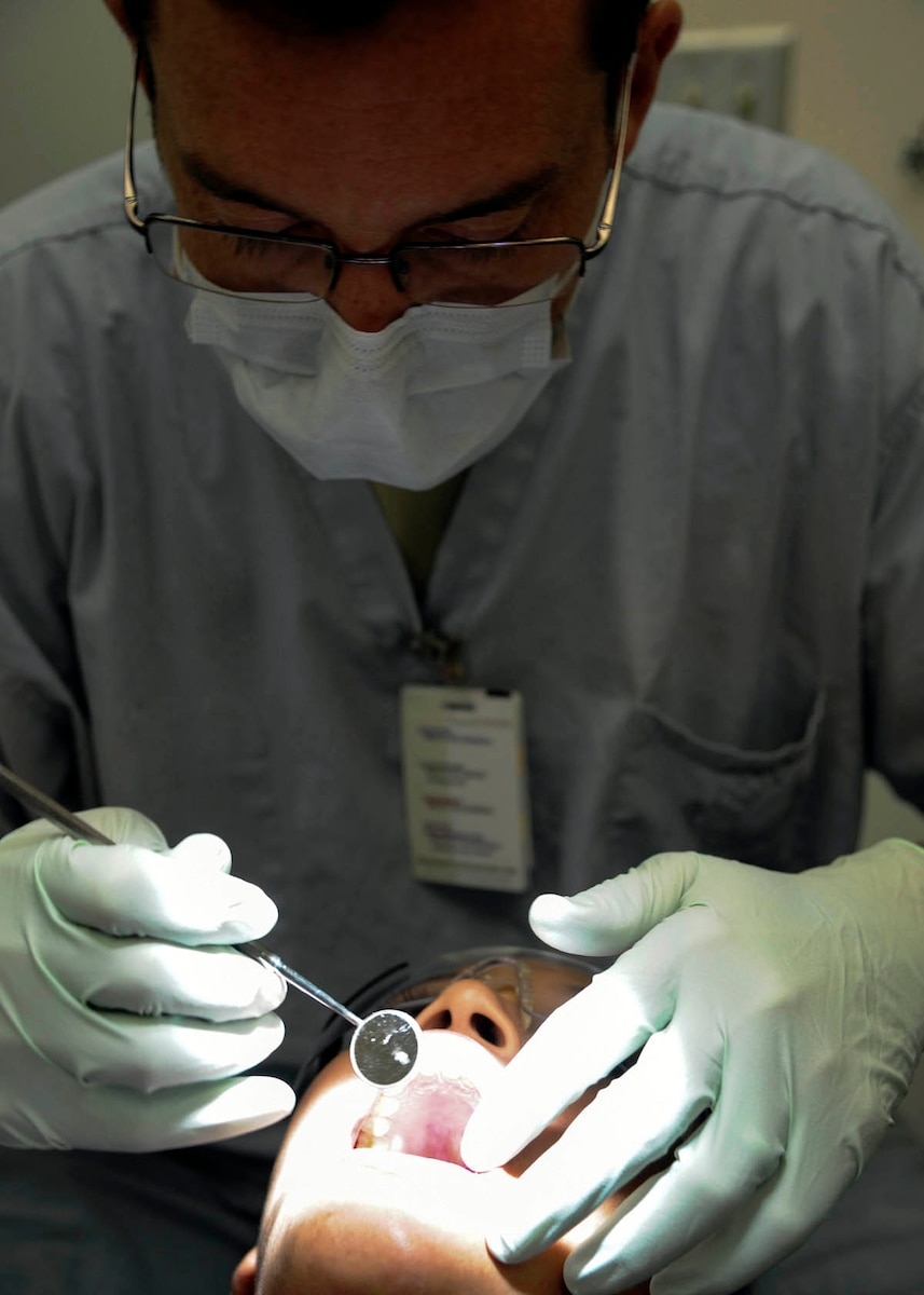 U.S. Air Force Capt. Riley Adams, a general dentist with the 59th Dental Squadron, examines Senior Airman Sherree Skeens’ teeth during her annual dental check-up Oct. 31 at the Dunn Dental Clinic on Joint Base San Antonio-Lackland, Texas. Adams was looking for inflamed lymph nodes, tissue abnormalities or any pigmentation or discoloration, which may signal oral cancers. Skeens is a dental assist assigned to the 59th DS. (U.S. Air Force photo/Staff Sgt. Kevin Iinuma)