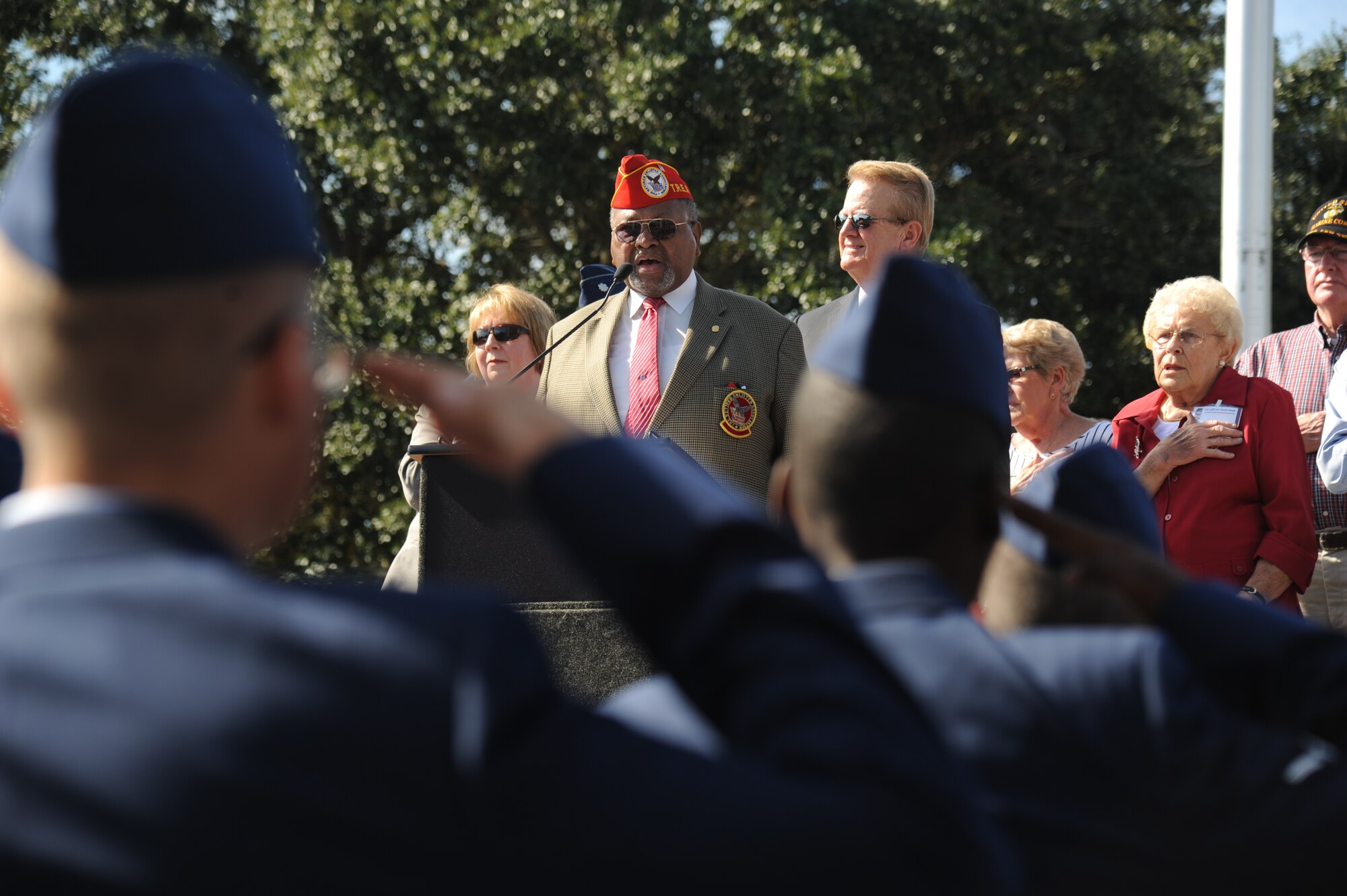 Retired Chief Master Sgt. Chris Moore, sings the National Anthem, as Keesler Airmen render a salute during the 13th Annual Gulf Coast Veterans Day Parade in front of City Hall Nov. 9, 2013, Biloxi, Miss. Keesler’s Wing leadership, Honor Guard, and Airmen, who carried the 50 State Flags, participated in the event. (U.S. Air Force photo by Kemberly Groue)