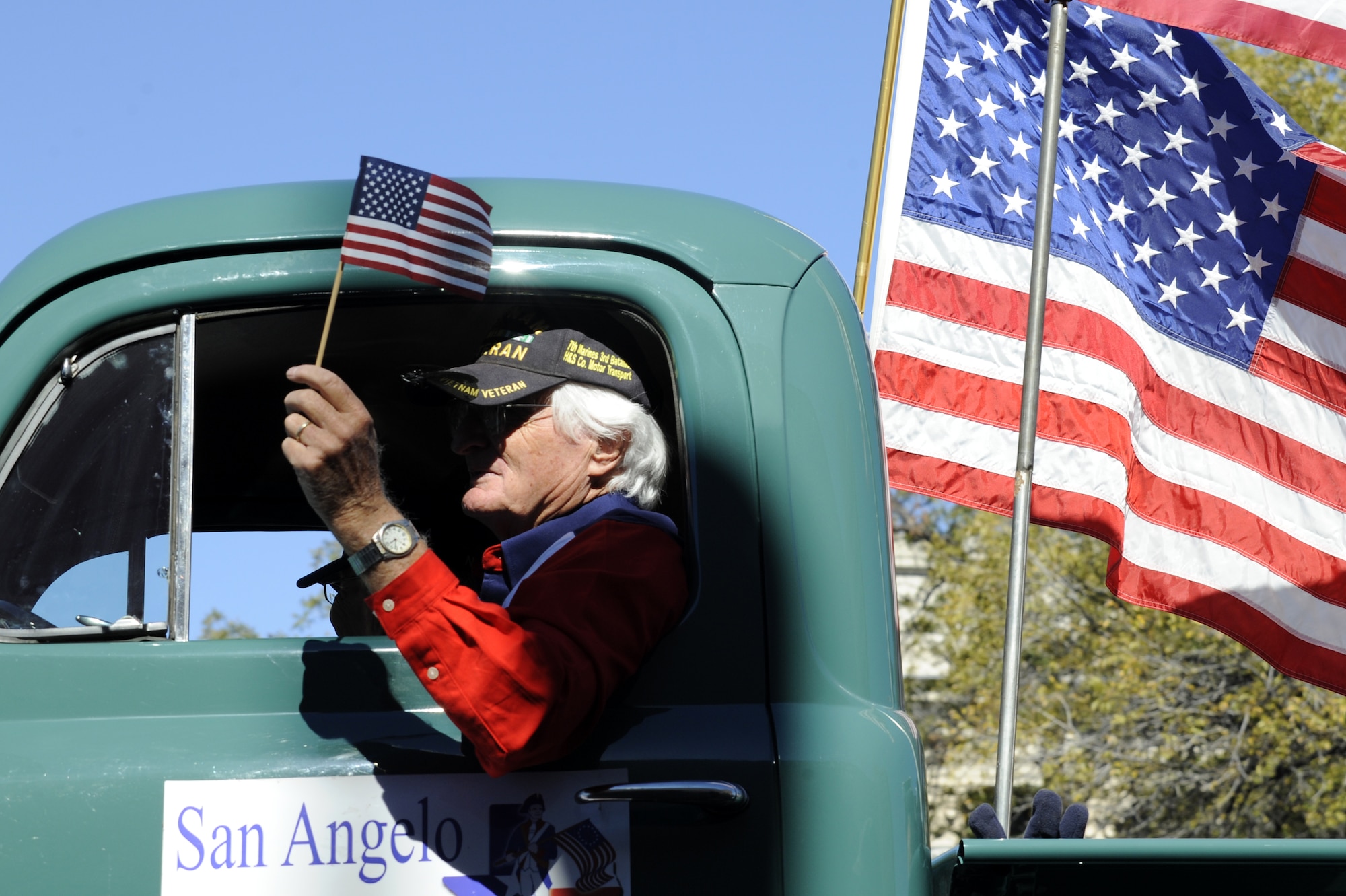 SAN ANGELO, Texas – An American veteran waves a flag as he drives his vehicle during the Veteran’s Day Parade Nov. 9 in historic downtown San Angelo. Volunteers from all over the San Angelo community volunteered to participate in the parade. (U.S. Air Force photo/ Staff Sgt. Austin Knox)