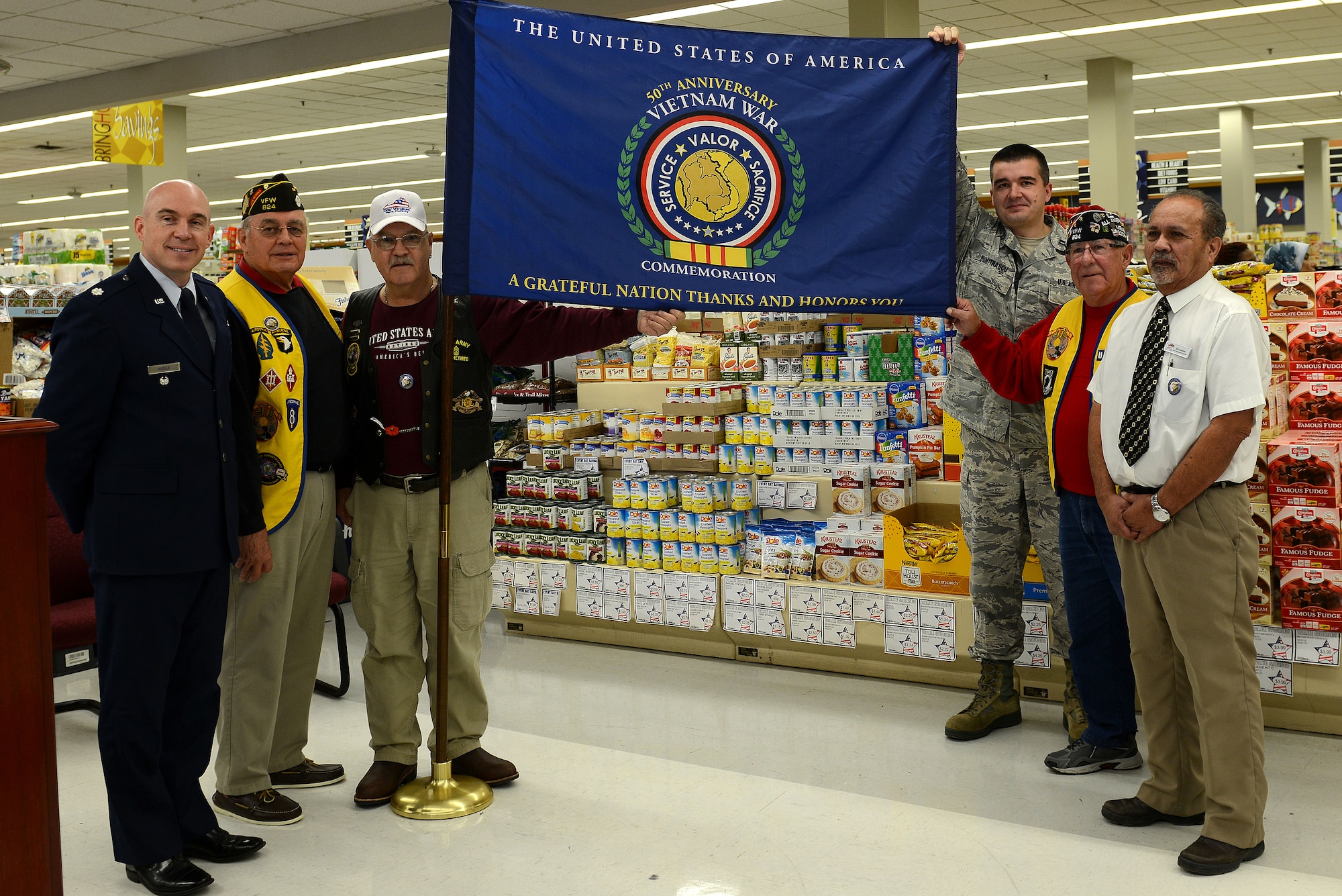 Retired and current Service members present the 50th Anniversary Vietnam War Commemoration flag at the Langley Air Force Base, Va., commissary, Nov. 9, 2013. The ceremony was held to recognize the valor and sacrifice of Service members who served in the Vietnam War, and to present a new Department of Defense-sponsored Vietnam War 50th anniversary flag. (U.S. Air Force photo by Airman 1st Class Kimberly Nagle/Released)